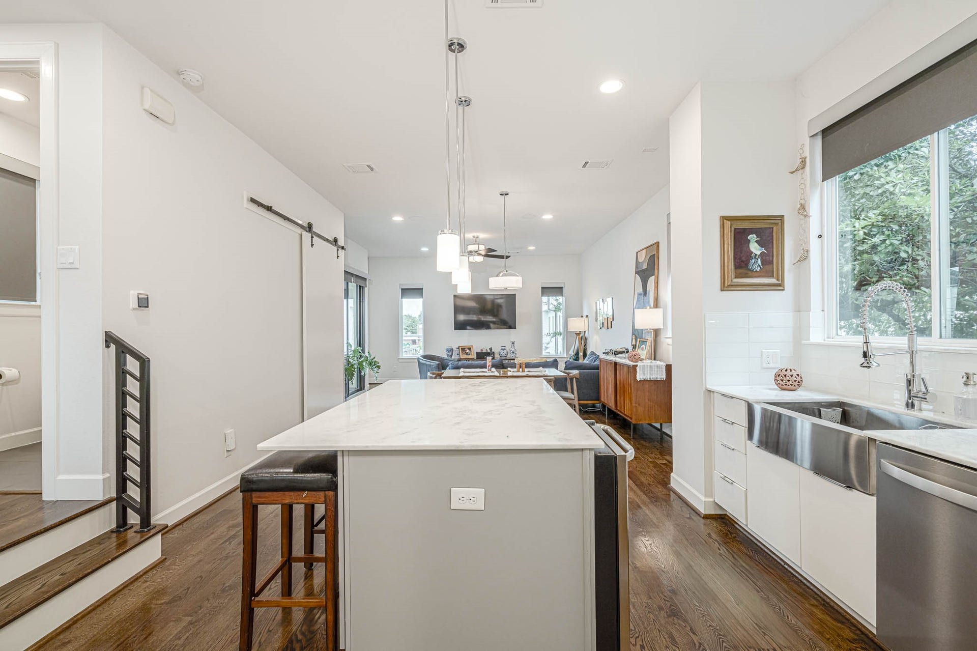 1615 Bingham Street, Houston, TX 77007 Modern kitchen with a sleek marble island, stainless steel farmhouse sink, and open layout leading to a cozy living area.