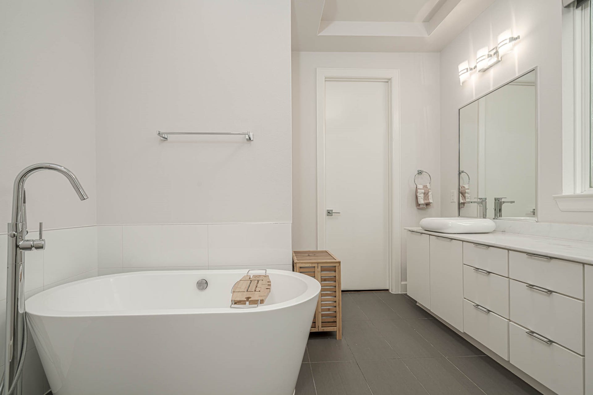 1615 Bingham Street, Houston, TX 77007 luxurious primary bathroom, featuring a sleek freestanding tub, modern fixtures, and elegant cabinetry.
