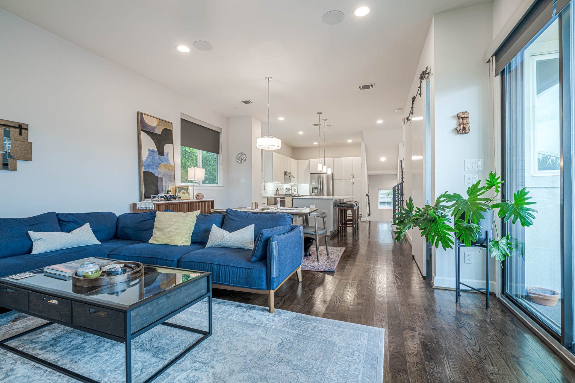 1615 Bingham Street, Houston, TX 77007 Spacious open-concept living area with sleek hardwood floors, a modern kitchen, and abundant natural light from large sliding glass doors. Ideal for entertaining or relaxing.