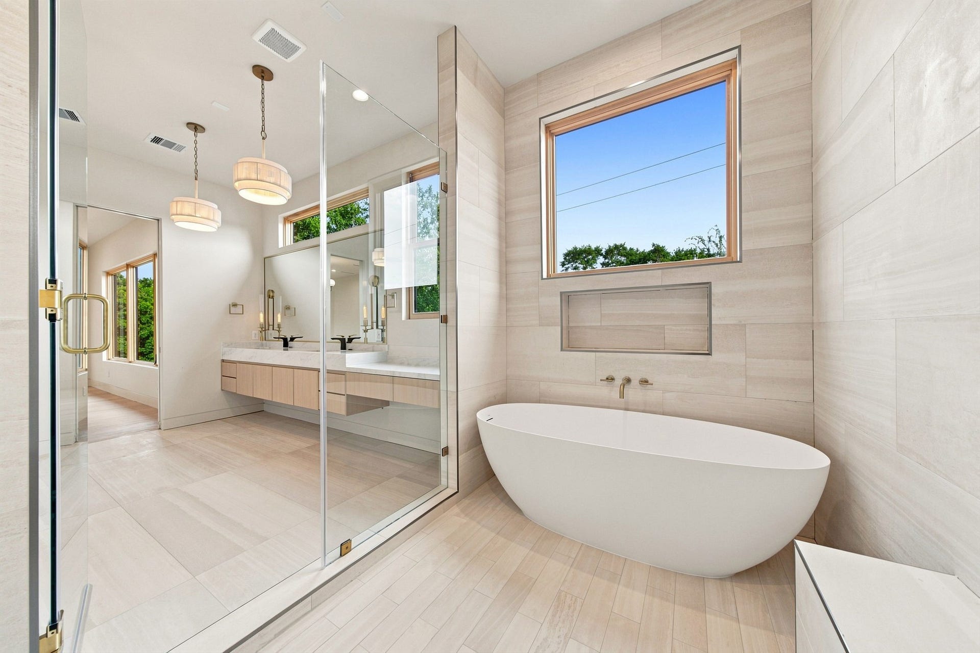 3023 Nottingham Street, West University Place, TX 77005 Natural limestone floor-to-ceiling surround - Natural travertine tile and Frameless glass shower enclosure.