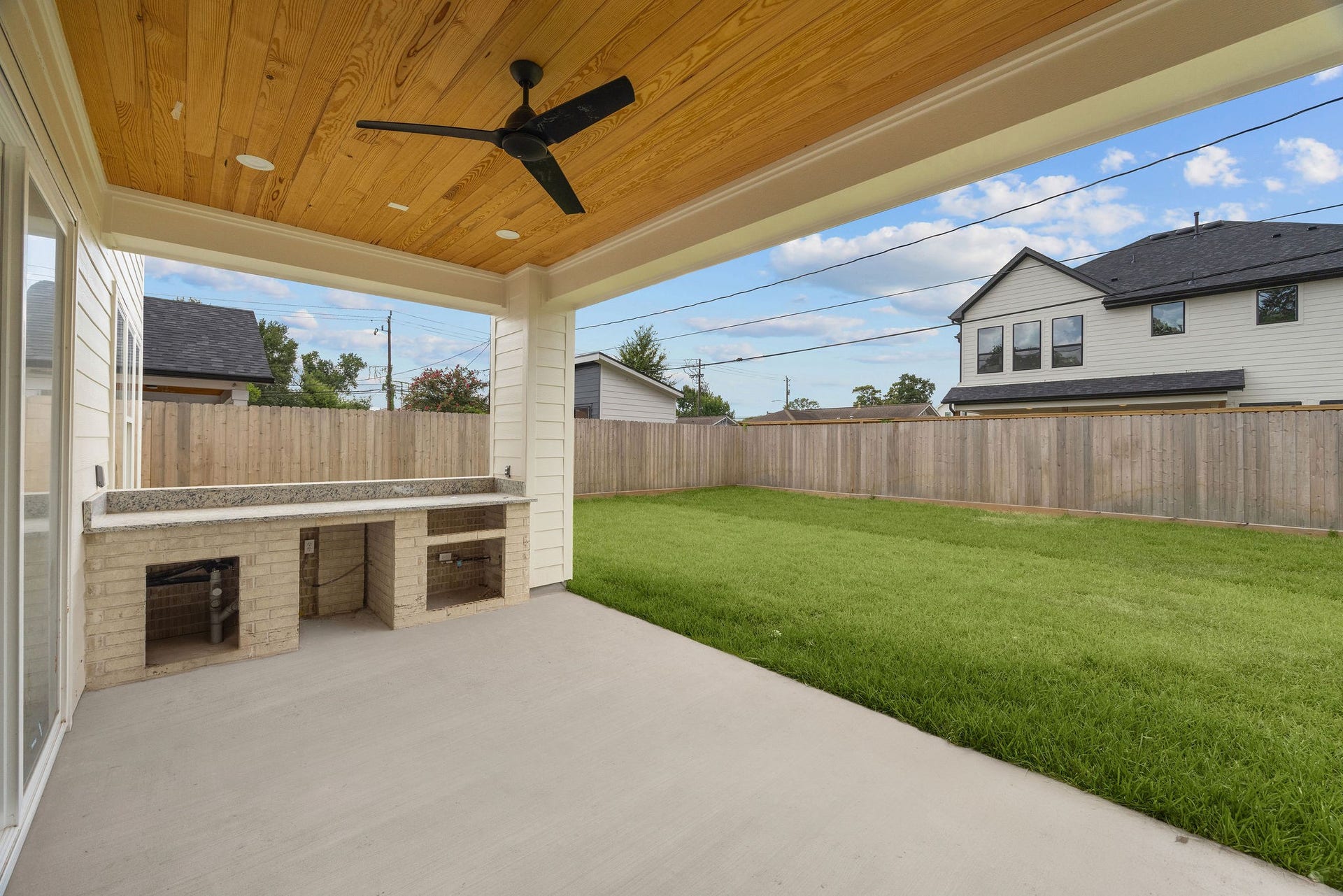1726 Saxon Drive, Houston, TX 77018 Outside, a covered outdoor kitchen overlooks a generous backyard.