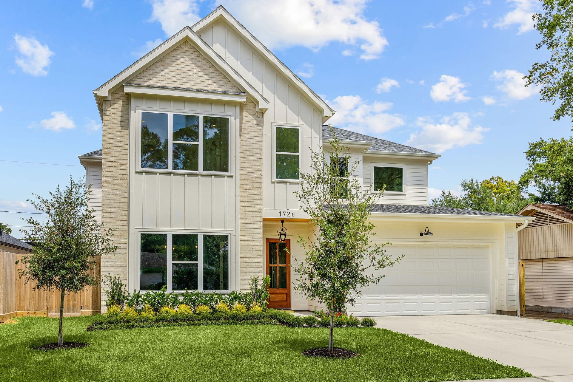 1726 Saxon Drive, Houston, TX 77018 Warm wood accents, timeless brick, and layered landscaping create an inviting front entry.