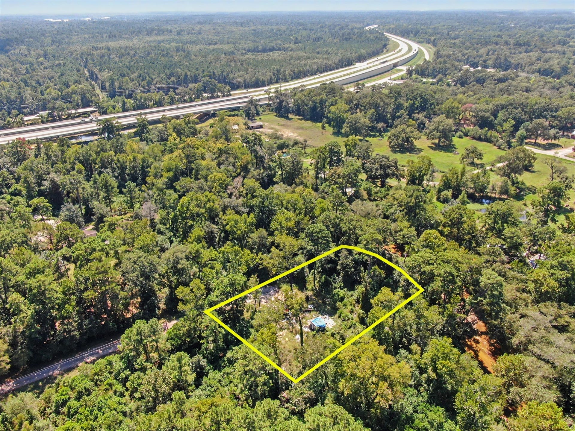 25589 Peach Creek Drive, New Caney, TX 77357 Wide view displaying the quiet road frontage and flexible building terrain.