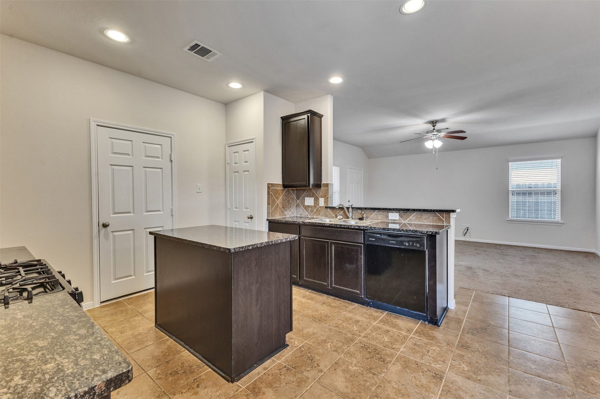 12915 Almeda Crossing Court, Houston, TX 77048 Open concept kitchen with center island and Sapphire granite countertops, flowing into the living area