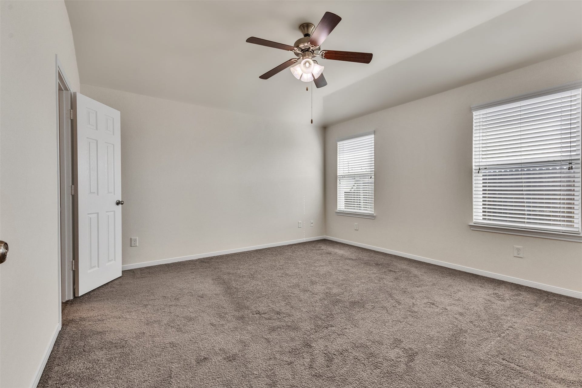 12915 Almeda Crossing Court, Houston, TX 77048 Spacious primary bedroom with ceiling fan and abundant natural light