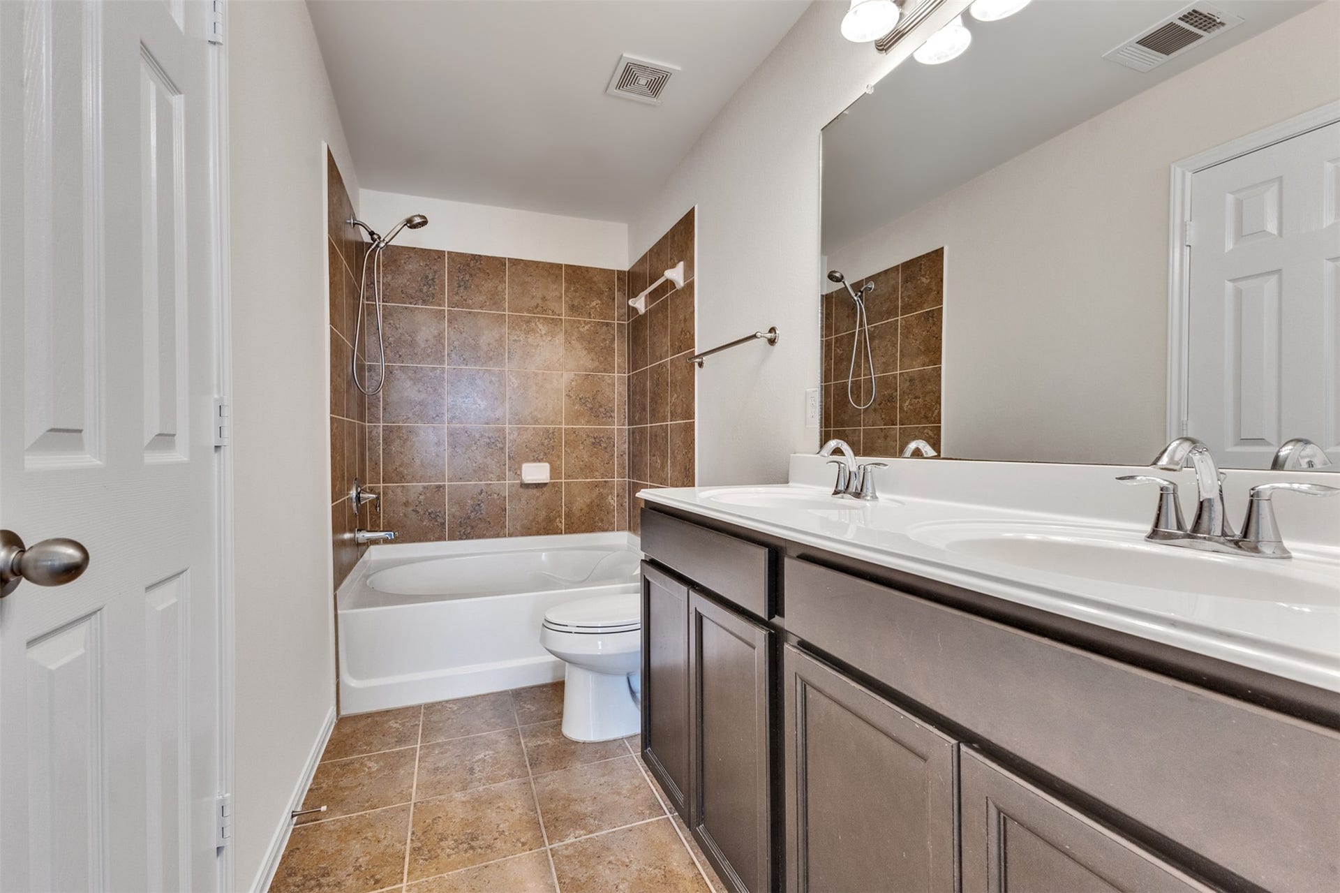 12915 Almeda Crossing Court, Houston, TX 77048 Primary bath with dual sinks, tub/shower combo, and tile surround.