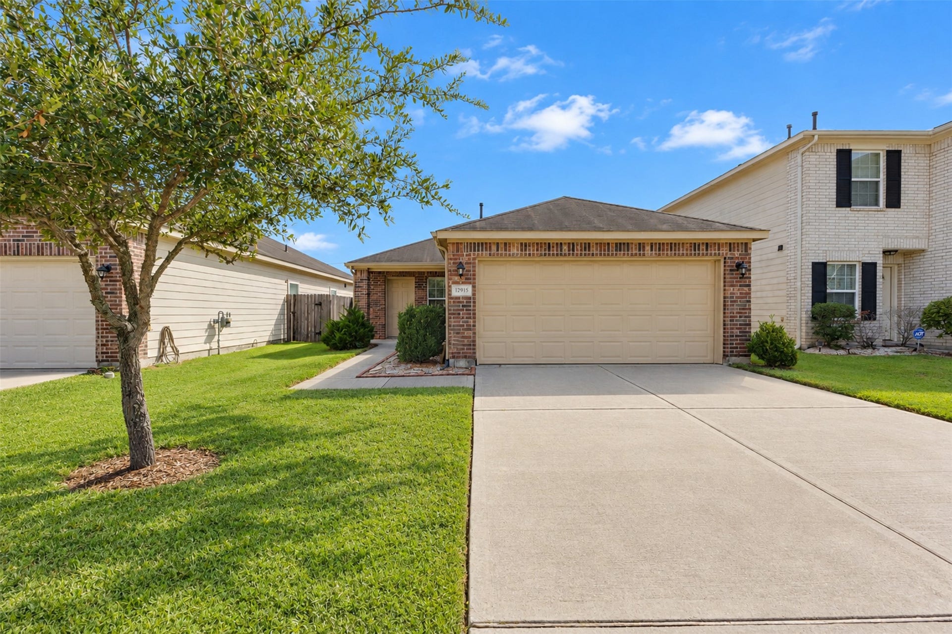 12915 Almeda Crossing Court, Houston, TX 77048 Charming one-story home with attractive curb appeal, a well-maintained lawn, mature landscaping, and an attached two-car garage.