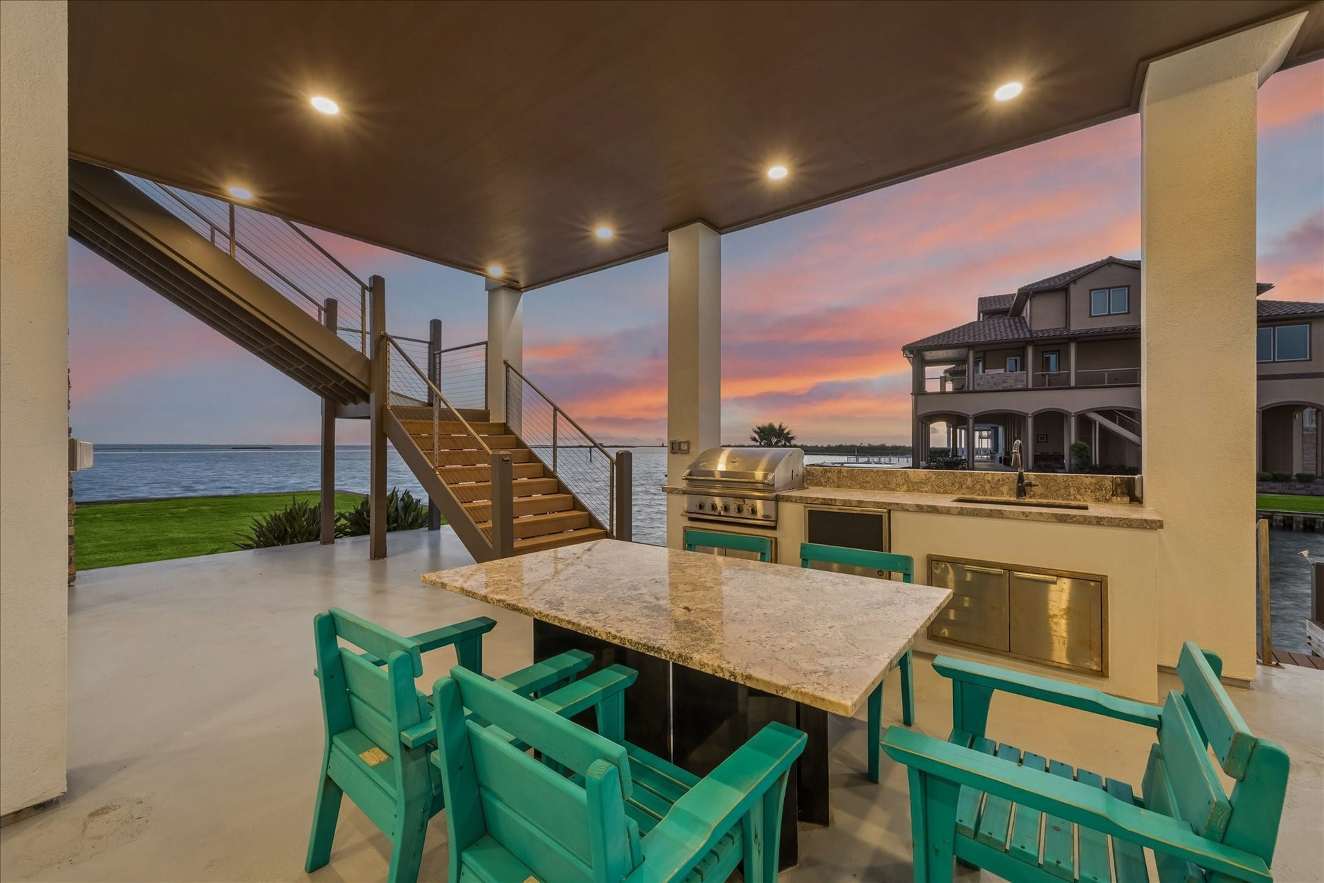 1 Water Key, Hitchcock, TX 77563 The ground-level entertaining space impresses with a covered lounge, outdoor kitchen, and custom built in table just steps from the bulkhead. Whether hosting sunset gatherings or launching from your back door, this home captures the best of Texas Gulf Coast living