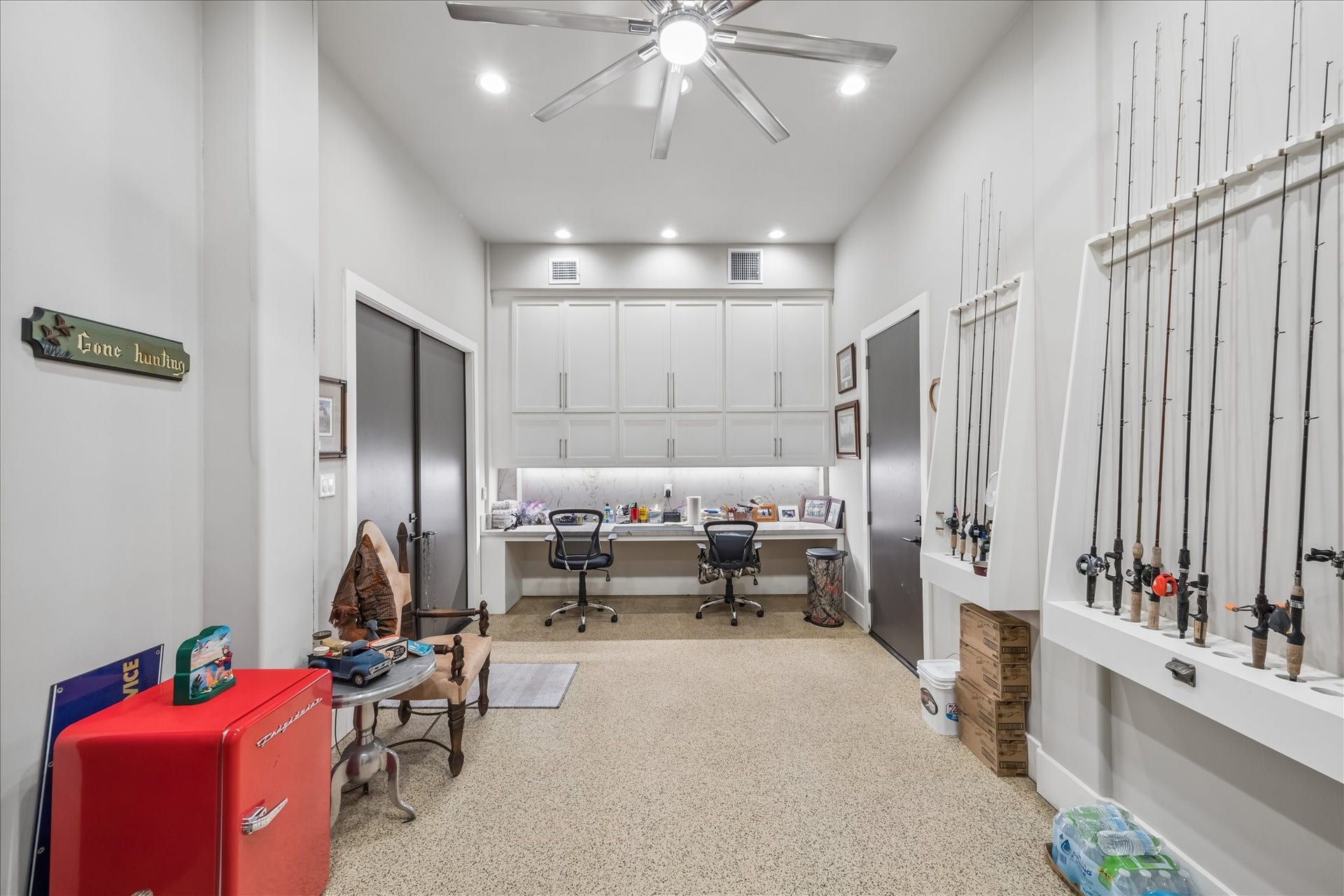 1 Water Key, Hitchcock, TX 77563 A spacious climate controlled tackle room is located on the ground level, featuring a built-in desk with an expansive workstation, abundant cabinetry for organized gear storage, and custom vertical racks designed to accommodate a large collection of fishing rods