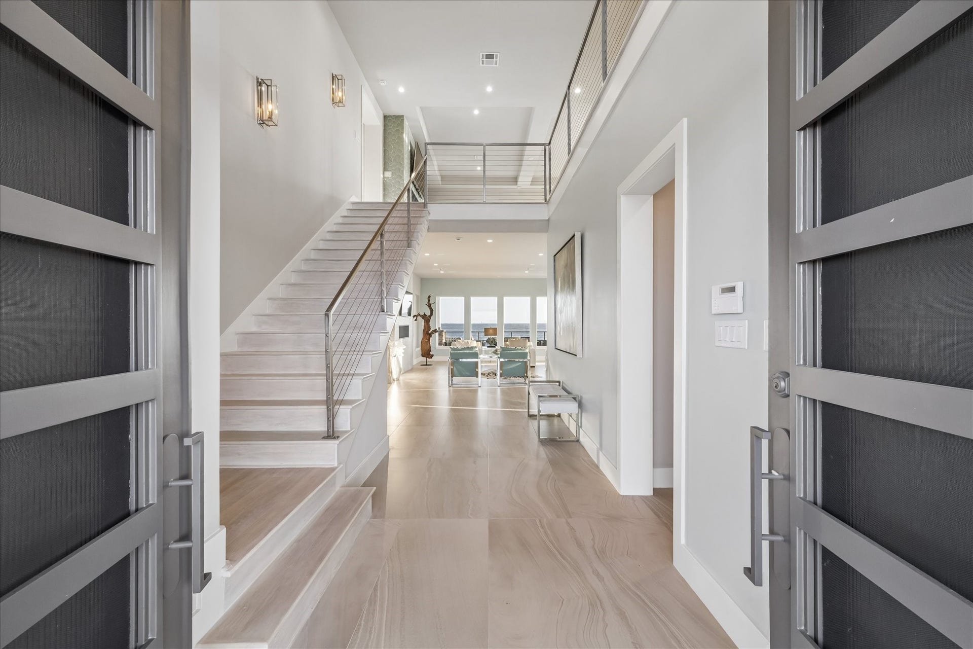 1 Water Key, Hitchcock, TX 77563 Upon entering through striking modern steel double doors, you are greeted by a light-filled foyer with soaring high ceilings and large 24" x 48" Eleganza tile flooring. The space draws your eye to the breathtaking views of West Galveston Bay, setting the tone for the homes refined, luxury design