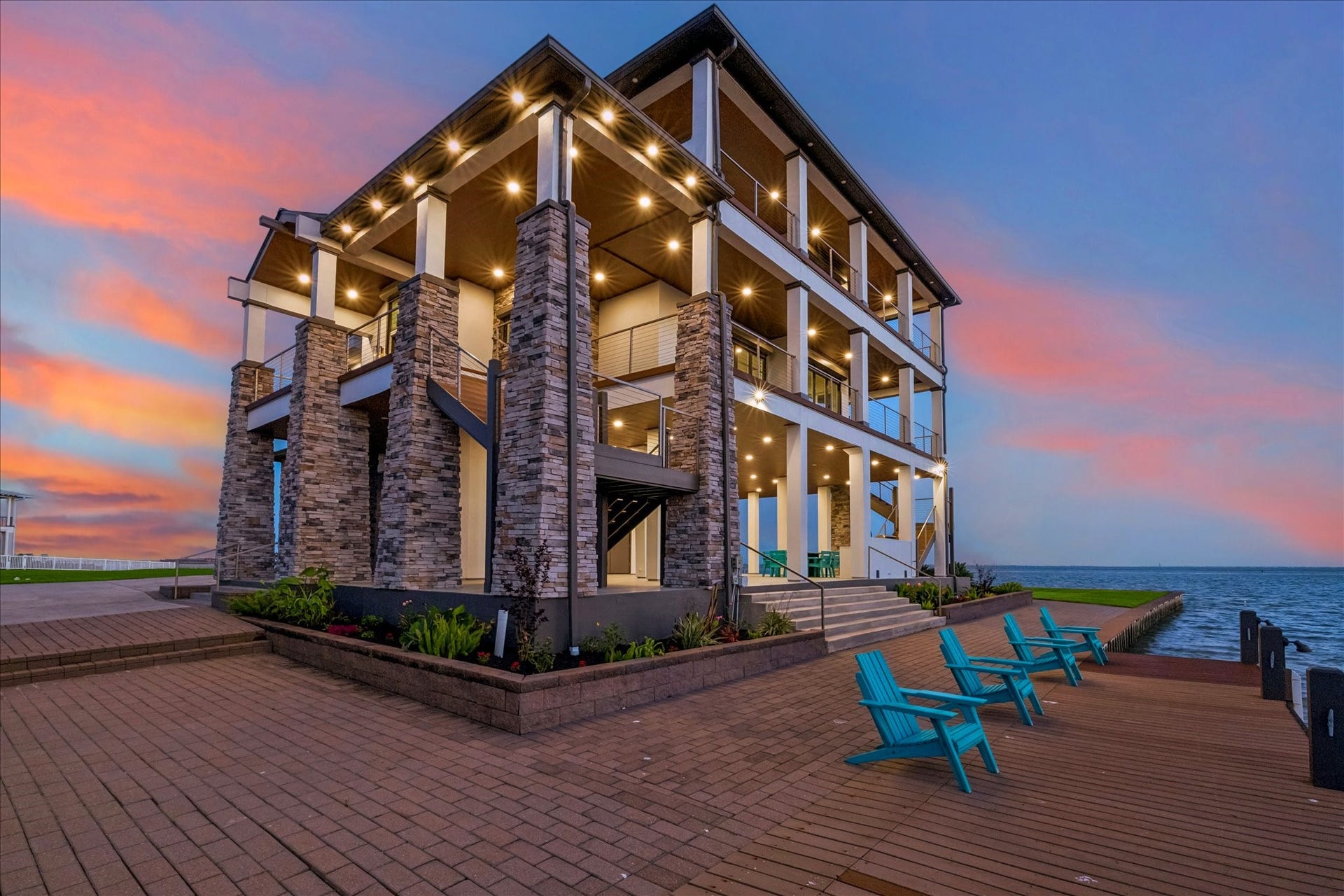 1 Water Key, Hitchcock, TX 77563 Elegant paver stone walkways surround the home, delivering a clean, sophisticated look with effortless maintenance, complemented by a dedicated dock and lounge area that offers breathtaking views
