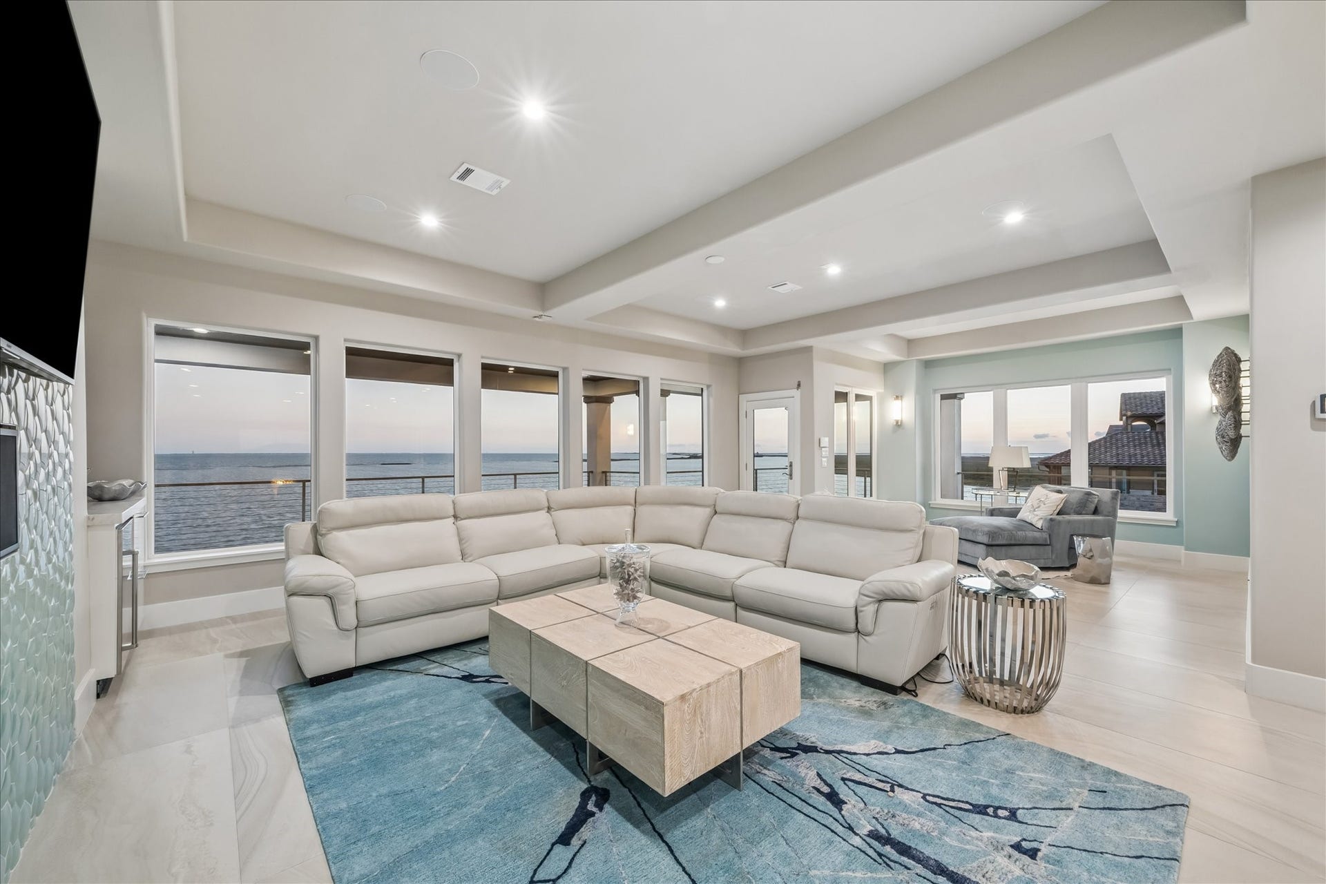 1 Water Key, Hitchcock, TX 77563 The second-level family room expands the footprint of leisure featuring a dual-zone layout with two distinct sitting areas designed to maximize the property's waterfront position. Floor-to-ceiling windows offer unobstructed views of West Galveston Bay and direct access to a private covered balcony