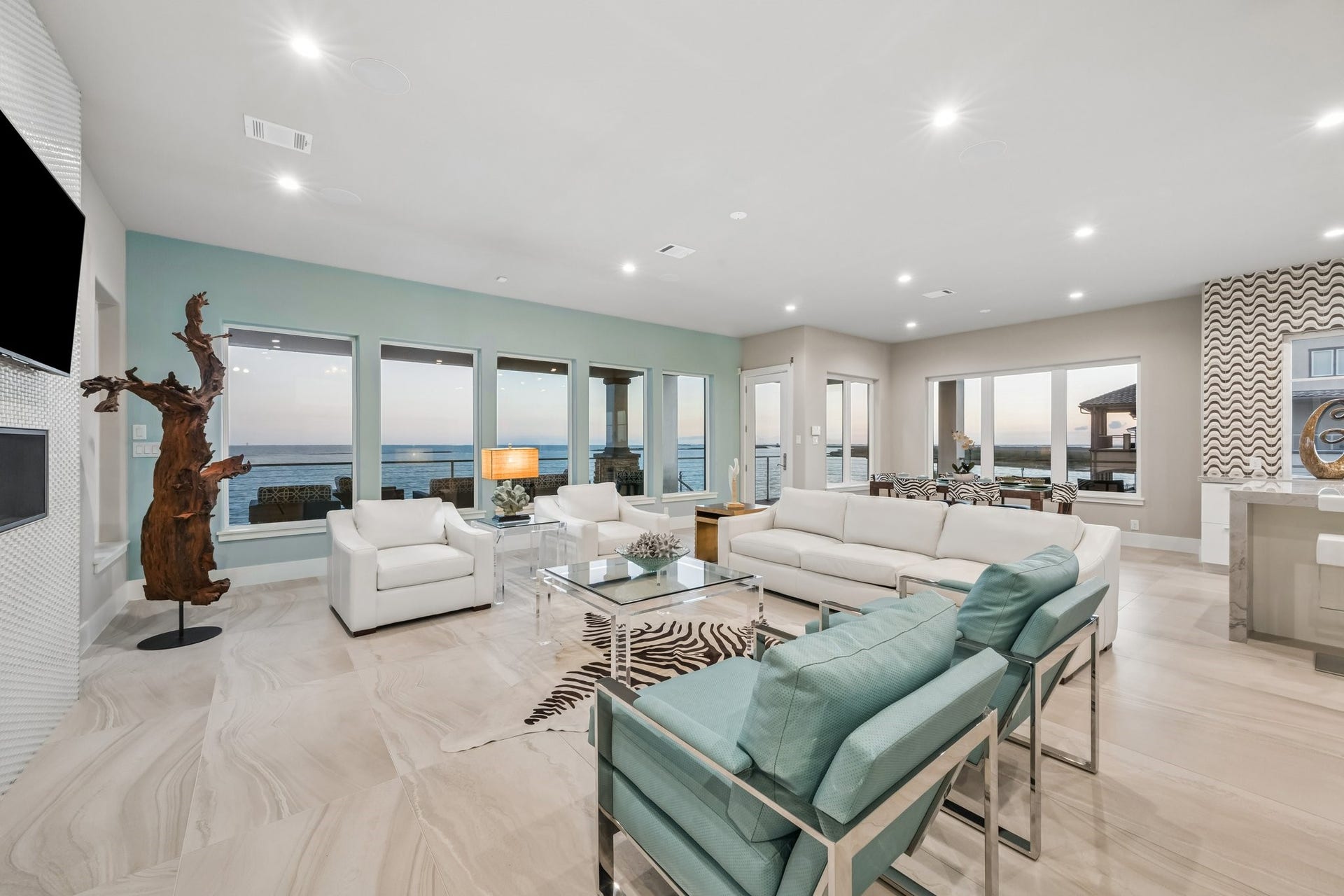 1 Water Key, Hitchcock, TX 77563 This light filled living area features large 24" x 48" tile flooring throughout, high ceilings with recessed lighting, and modern comfort, all complemented by a wall of windows capturing the stunning views