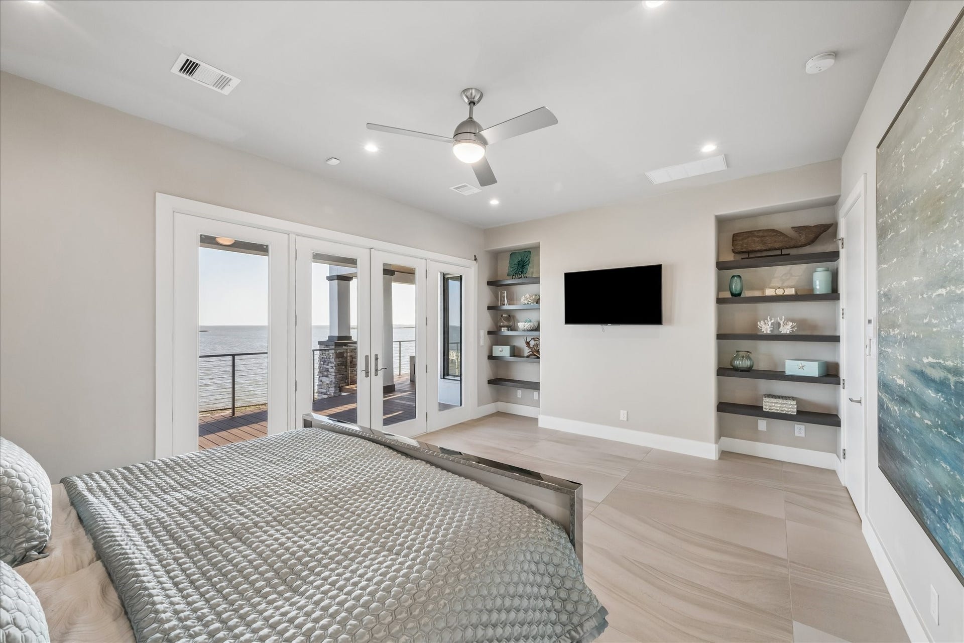 1 Water Key, Hitchcock, TX 77563 This modern primary bedroom comes fully furnished, showcasing neutral tones and open built-in shelving for stylish display and convenient storage