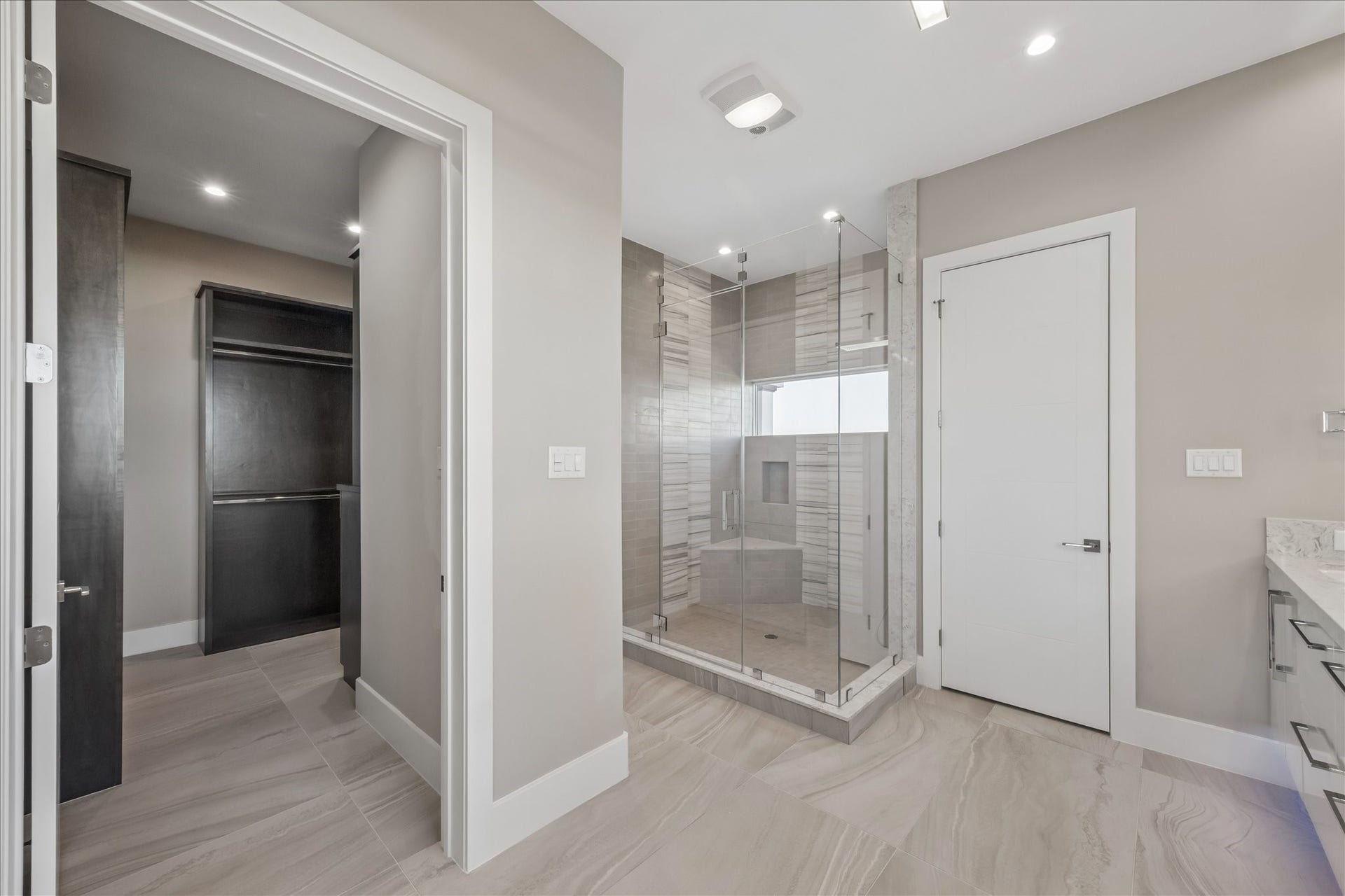 1 Water Key, Hitchcock, TX 77563 To the left of the vanities there is a large walk in closet full of built-in organization and a spacious frameless walk-in shower featuring a built-in bench and a multi-jet rainfall panel