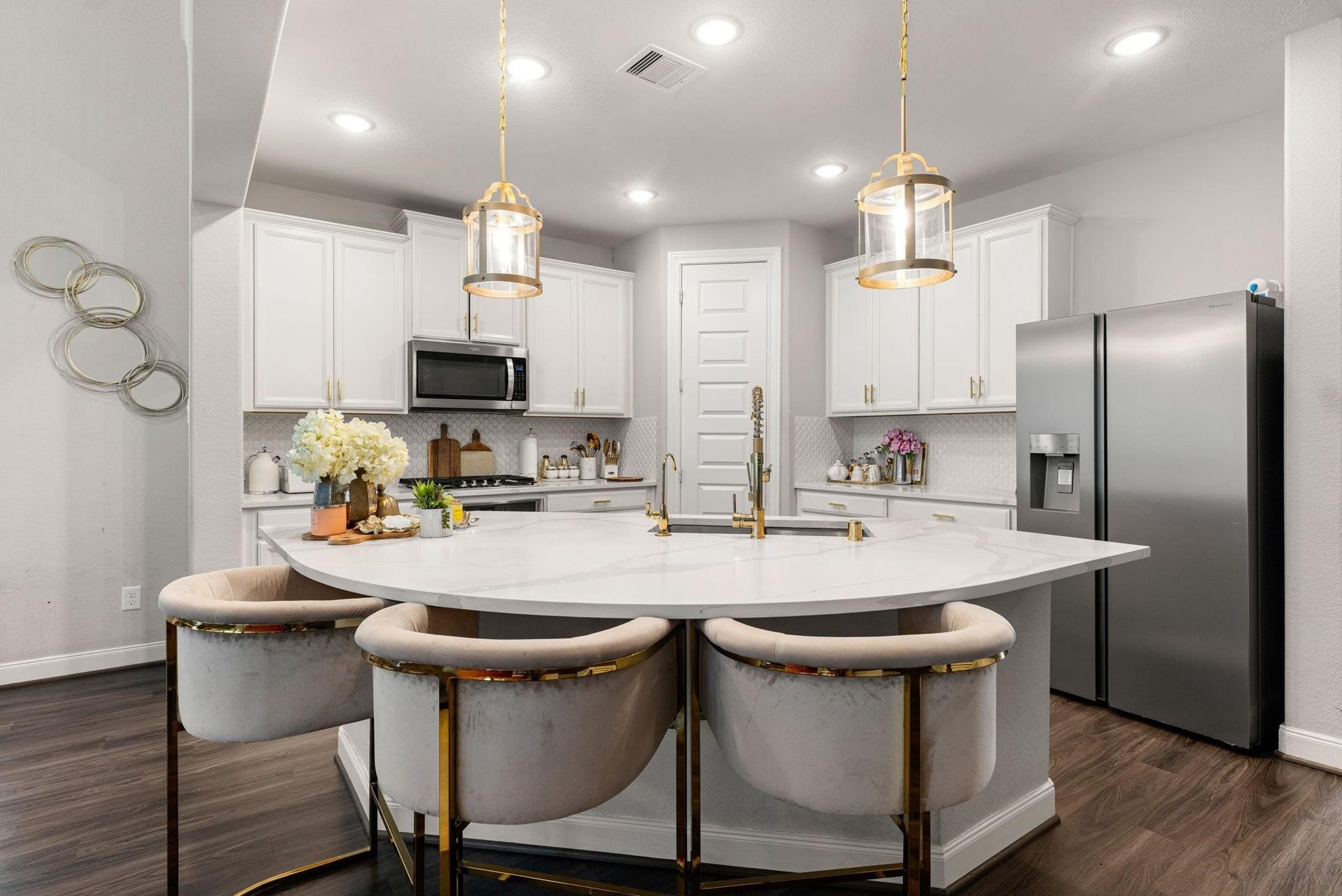 20422 Alpine Meadow Place, Richmond, TX 77407 The kitchen centers around a massive curved island with bar seating, while lined with pristine white cabinetry.