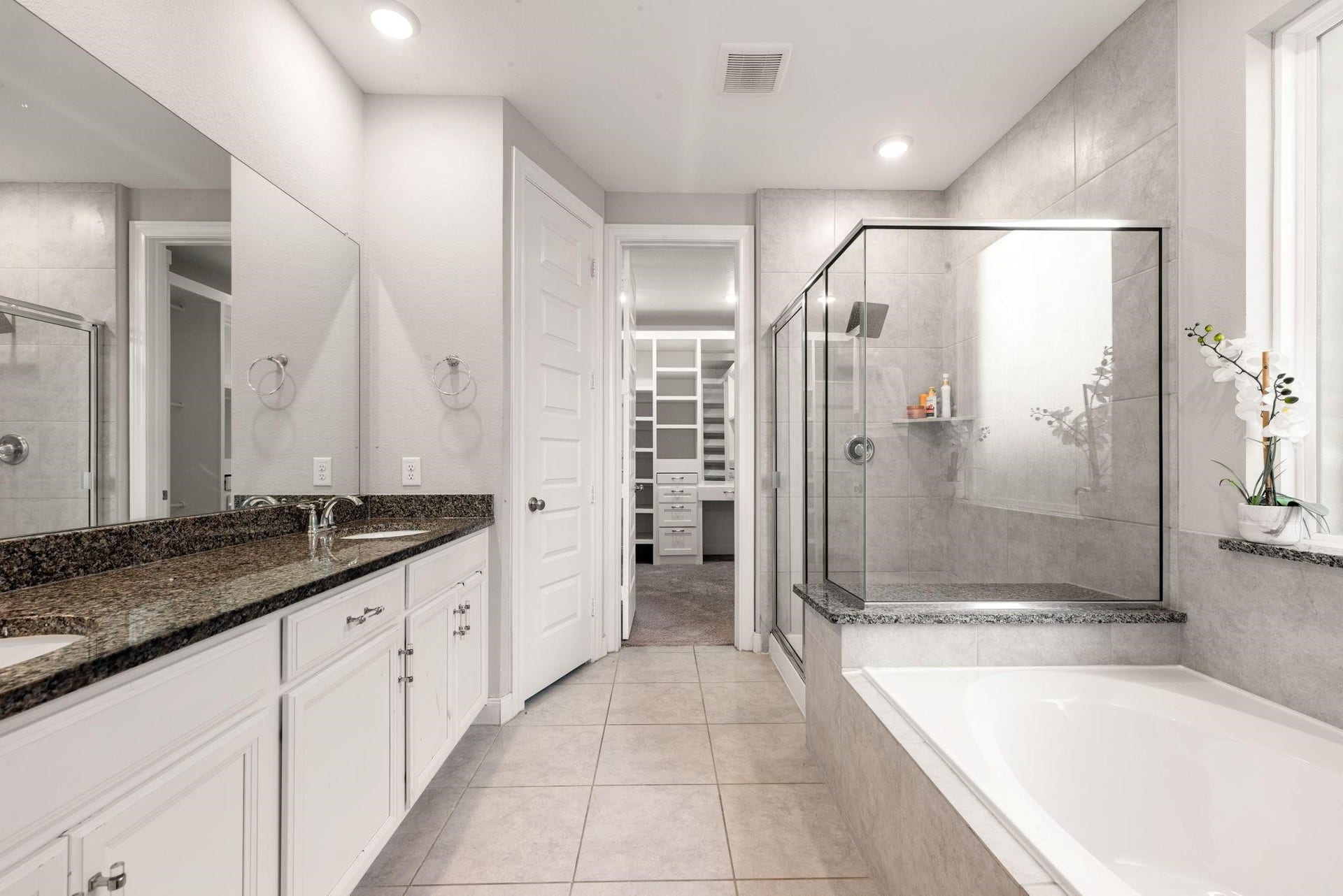 20422 Alpine Meadow Place, Richmond, TX 77407 The primary bath is spa-inspired, with double sinks, a deep soaking tub, and a separate glass-enclosed shower.