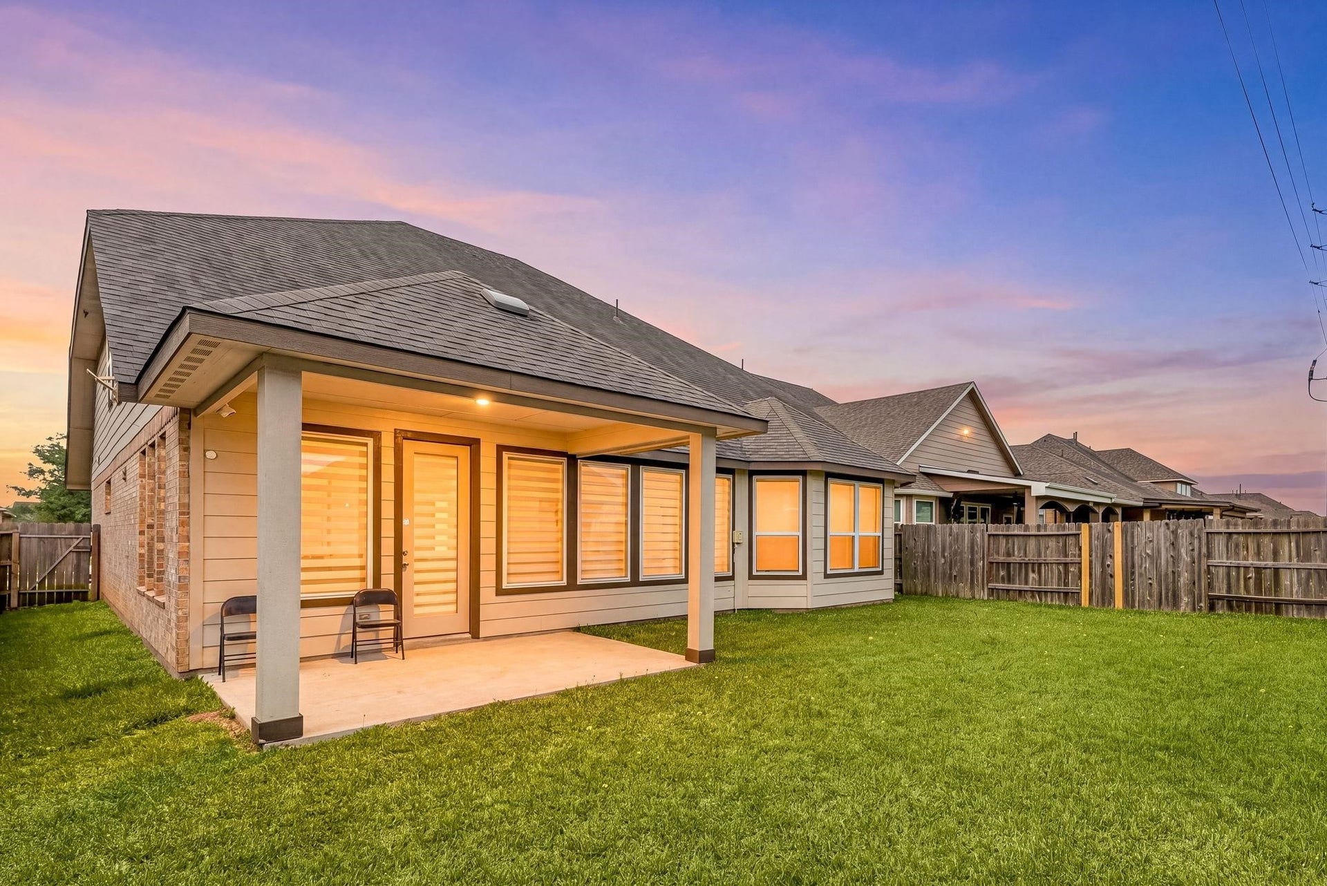 20422 Alpine Meadow Place, Richmond, TX 77407 An evening look at the back of the house highlighting the covered patio and clean lines of the rear elevation.