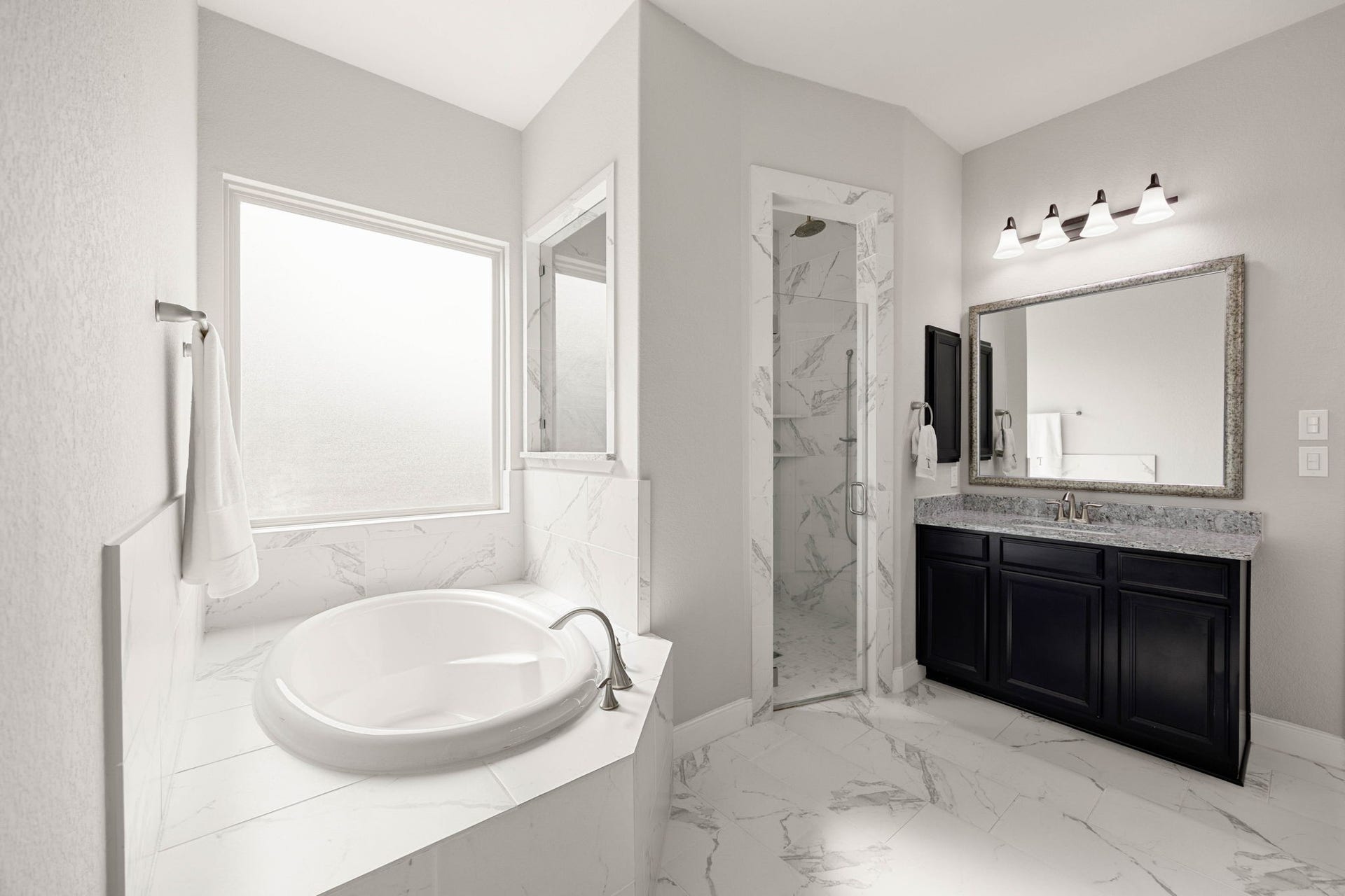 A closer look at the primary bath highlights the separate vanities, generous counter space and polished finishes throughout.