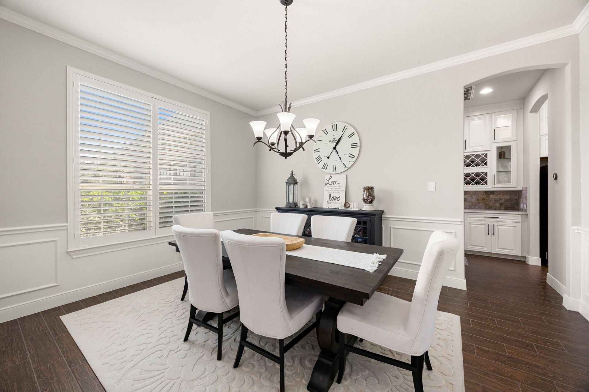 The formal dining room features a chandelier and a large window that fills the space with natural light, creating an elegant setting for hosting gatherings.
