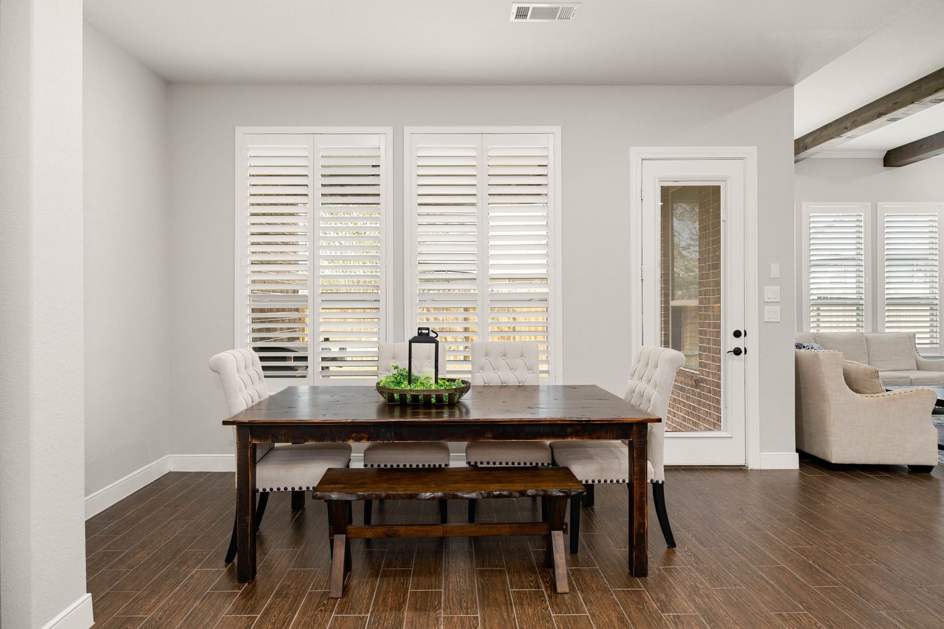 The sunlit breakfast area offers a casual dining space with shutters and direct backyard access, perfect for everyday meals.