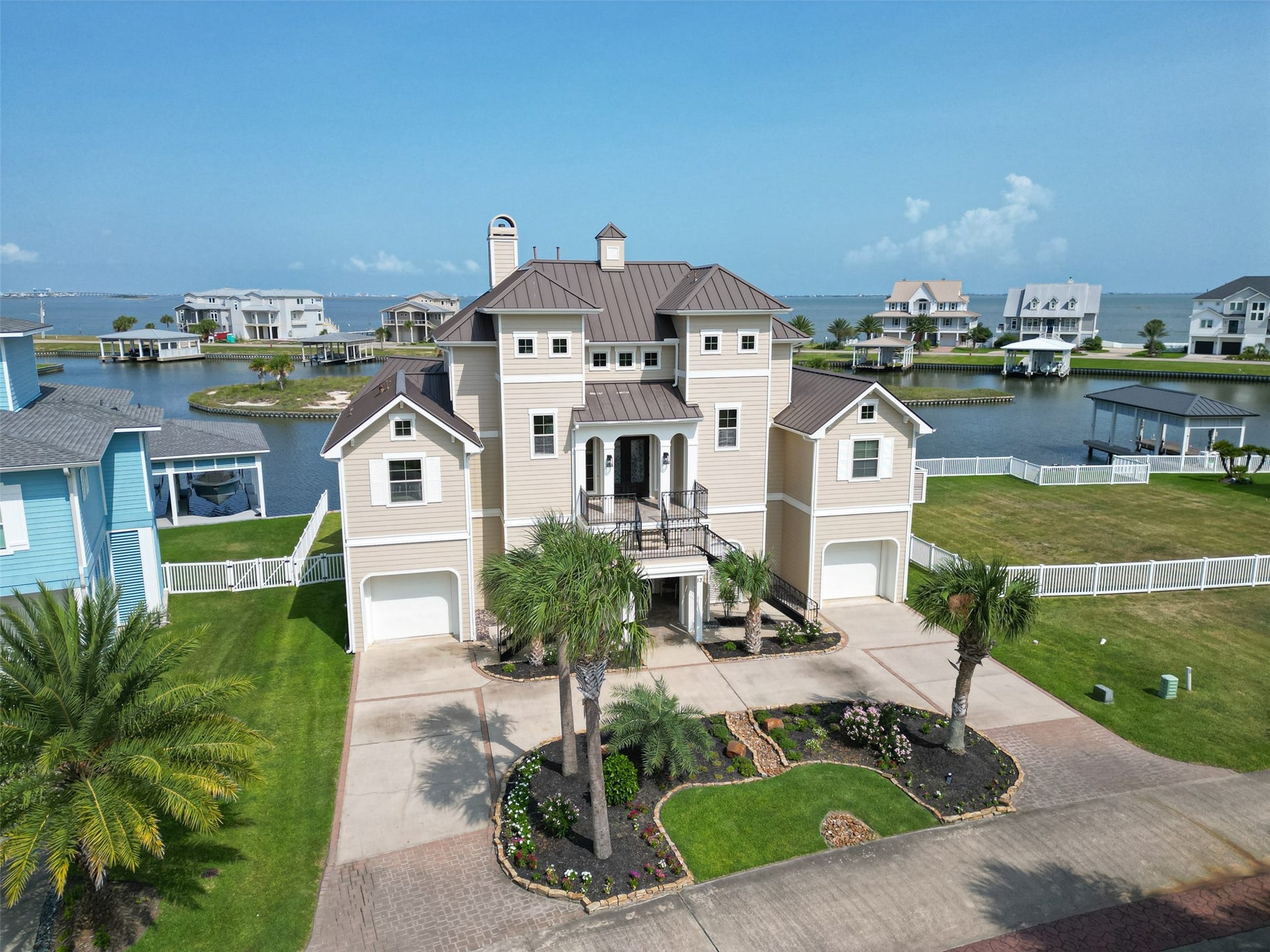 13 Sugarloaf, Hitchcock, TX 77563 Stunning coastal home with elegant architecture, nestled by serene waterfront views, featuring a beautifully landscaped front yard and spacious dual garages.