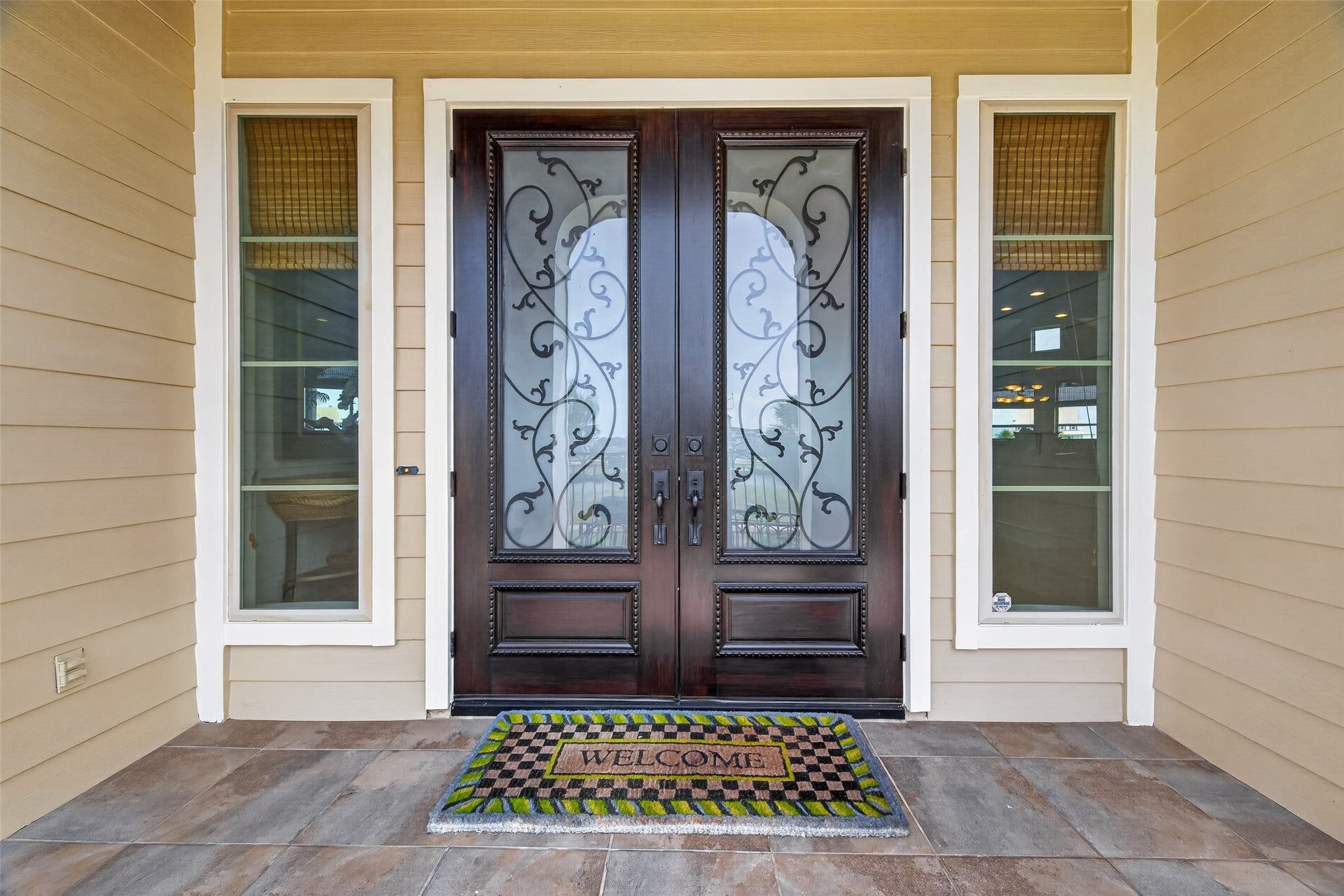 13 Sugarloaf, Hitchcock, TX 77563 Elegant entrance featuring a beautifully crafted double door with intricate glass detailing, flanked by tall windows and a welcoming mat.