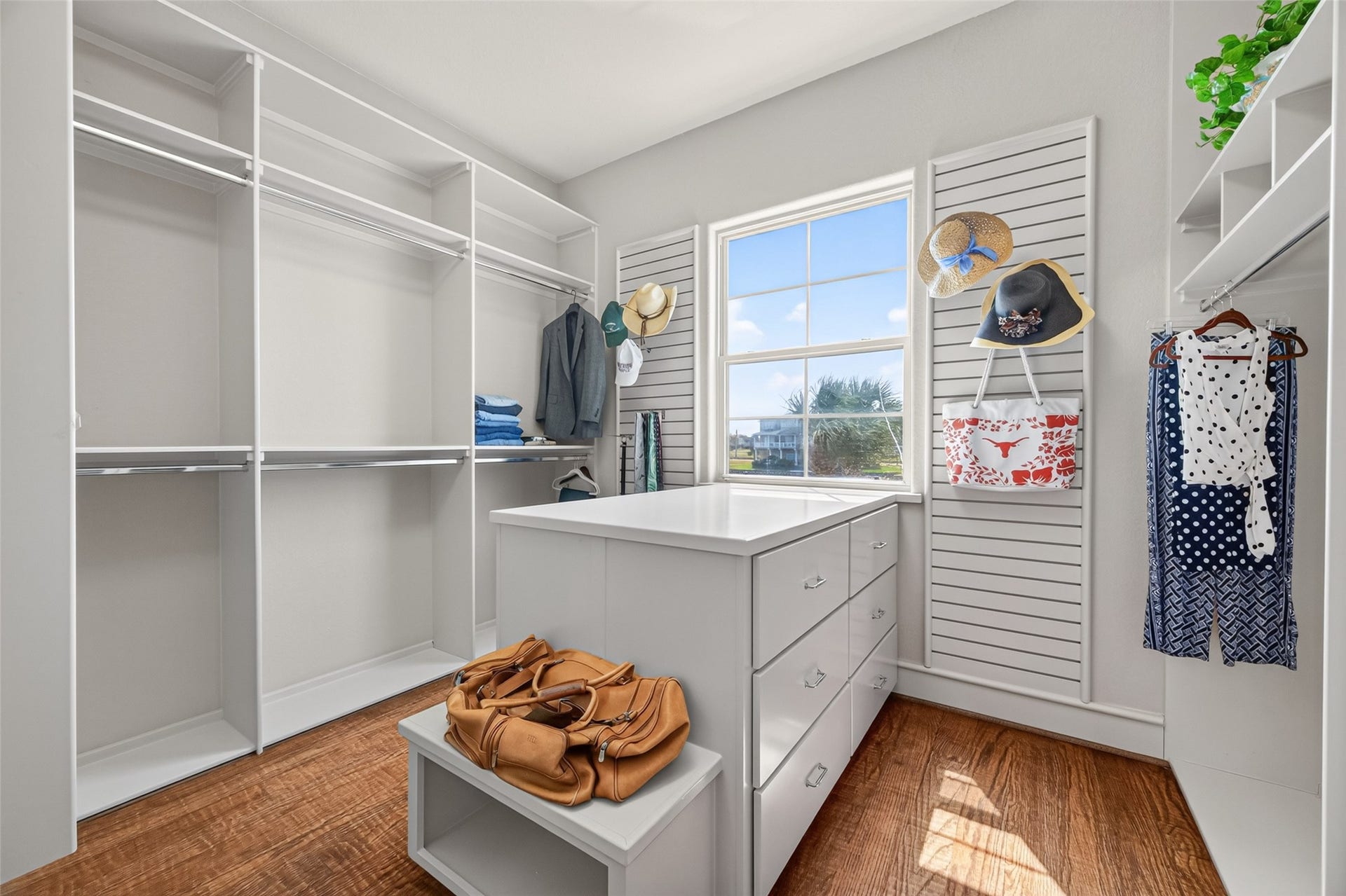 13 Sugarloaf, Hitchcock, TX 77563 Spacious walk-in closet featuring ample shelving and hanging space, an island with drawers, and a bright window for natural light.