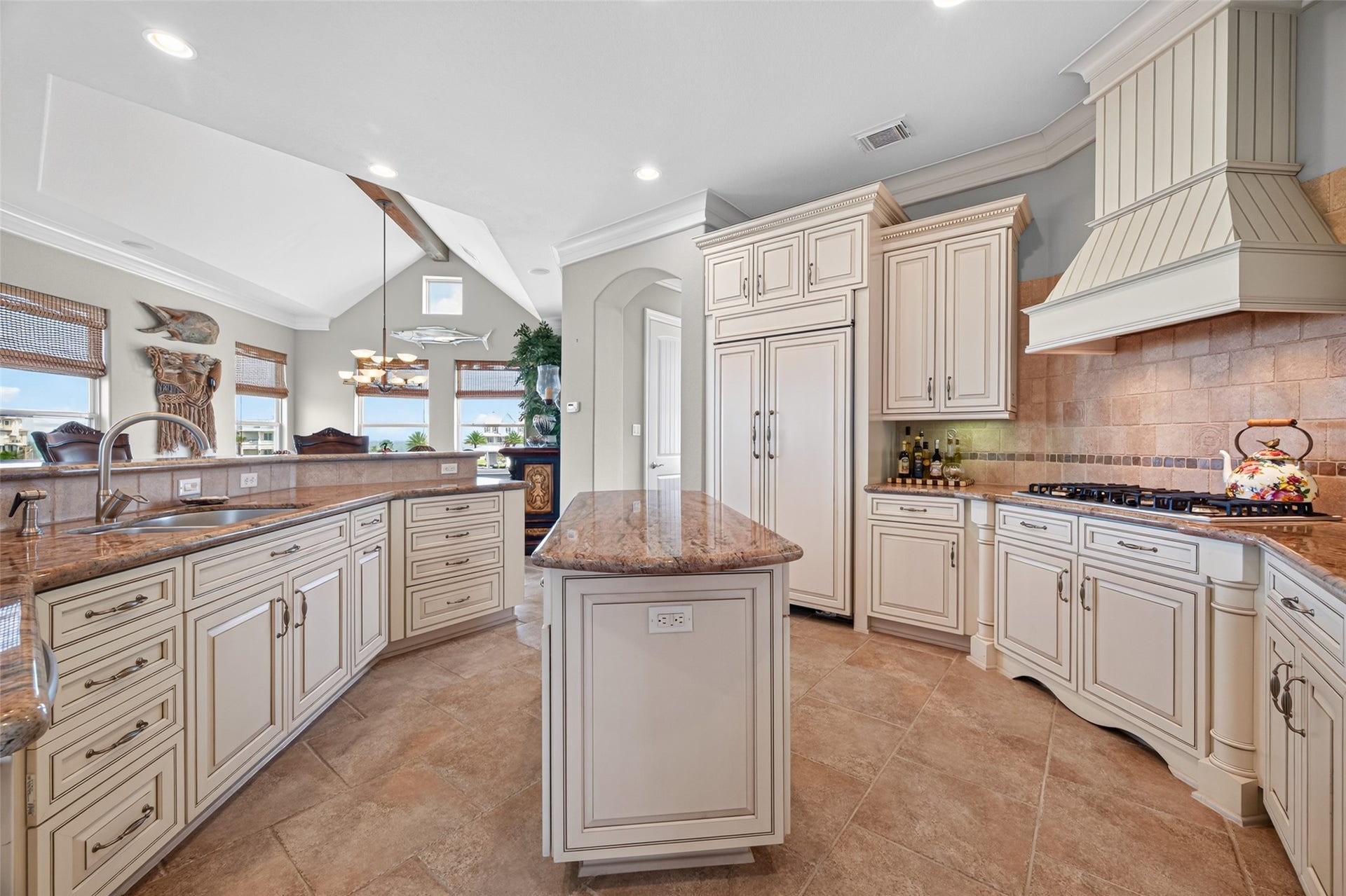 13 Sugarloaf, Hitchcock, TX 77563 Elegant kitchen featuring custom cabinetry, a spacious island with granite countertops, and a high-end range with a decorative hood.