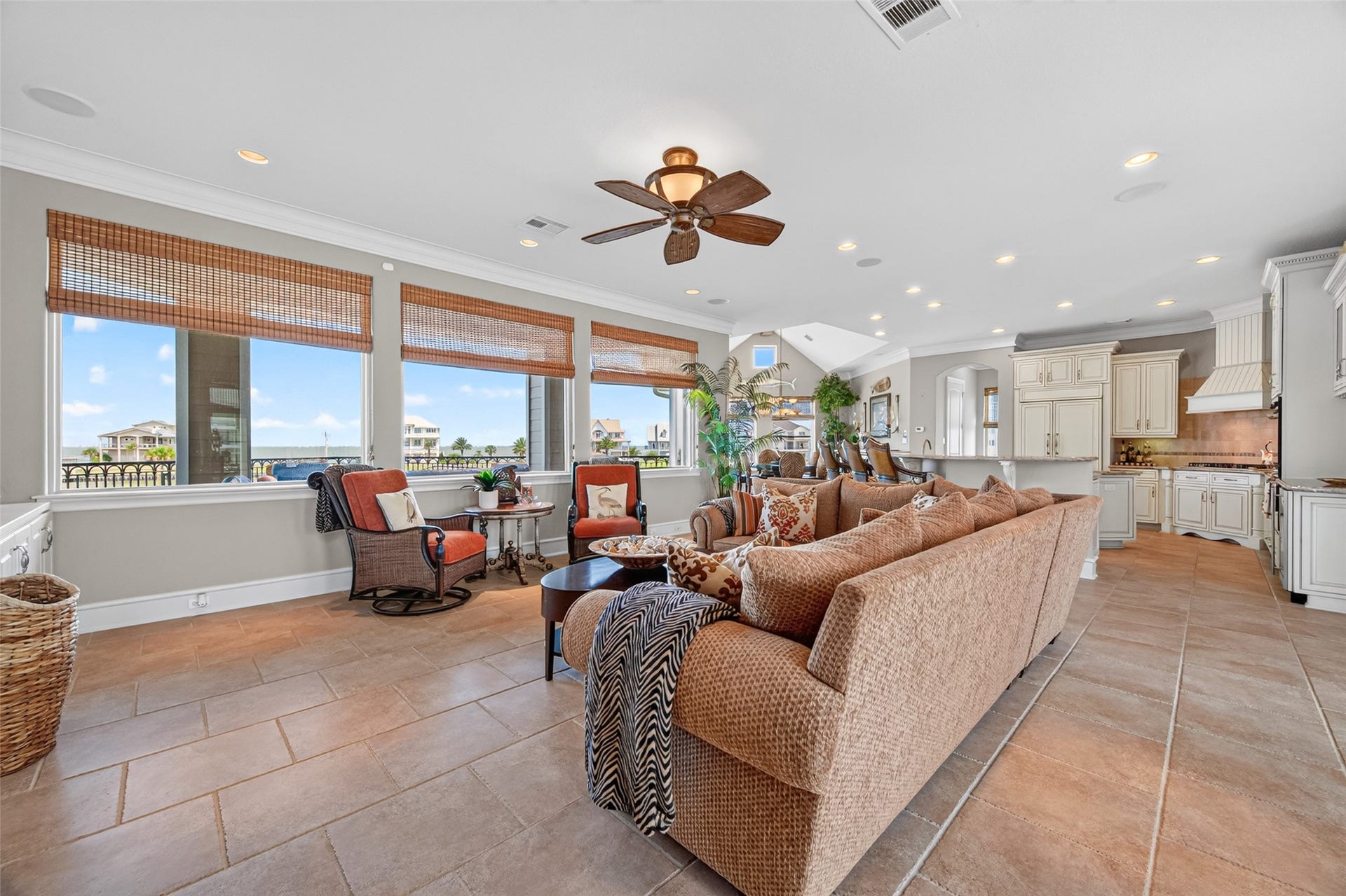 13 Sugarloaf, Hitchcock, TX 77563 Spacious open-concept living area with abundant natural light, featuring a cozy seating arrangement, tile flooring, and a modern kitchen equipped with elegant cabinetry.