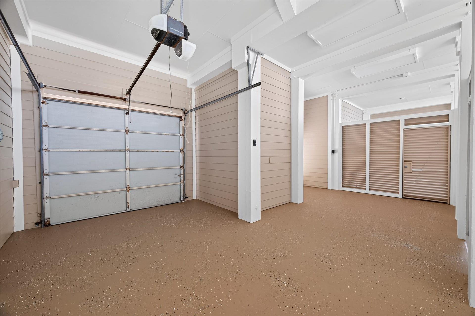 13 Sugarloaf, Hitchcock, TX 77563 Spacious and well-lit garage with a modern automatic door and ample room for storage or parking.