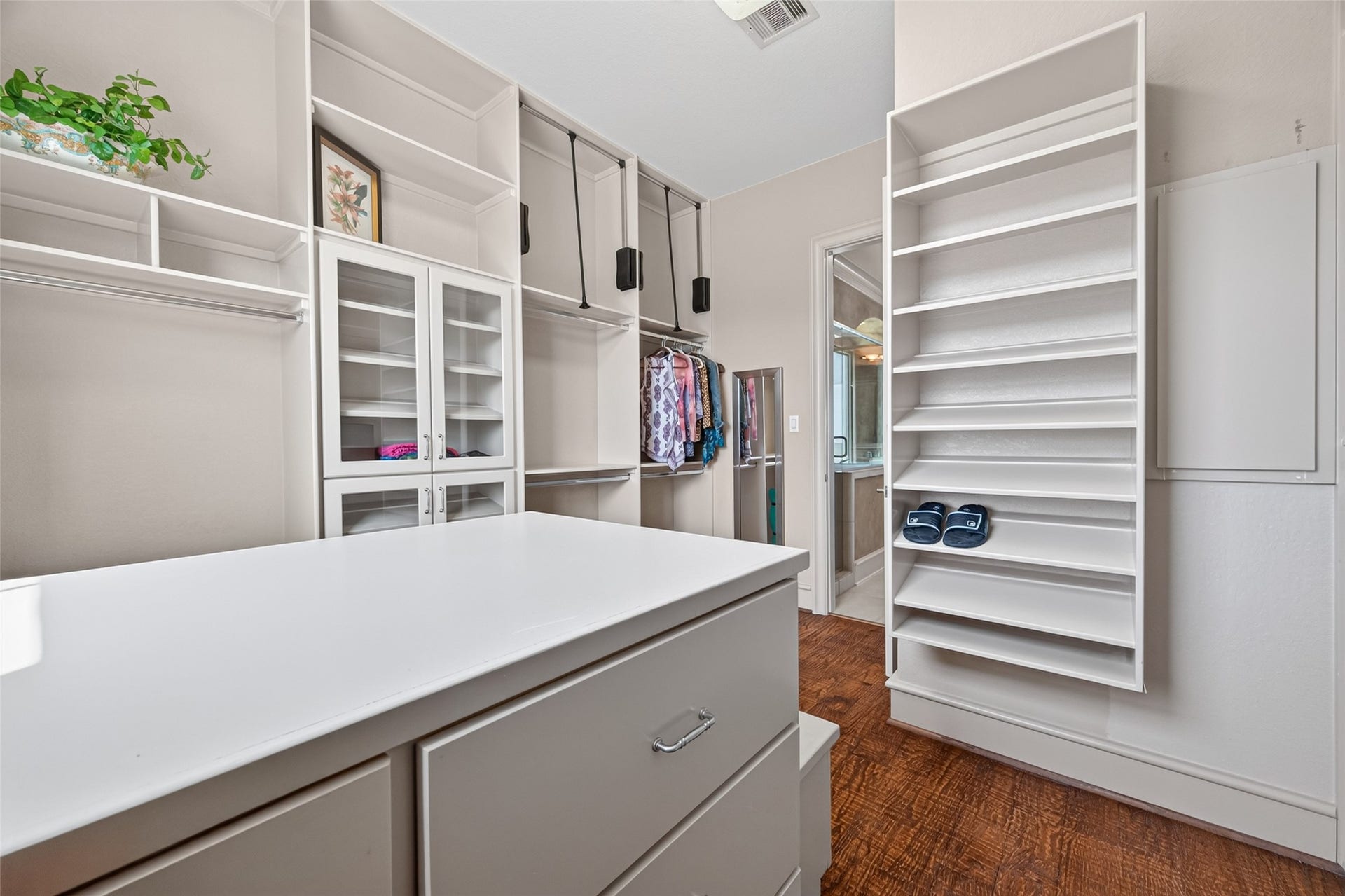 13 Sugarloaf, Hitchcock, TX 77563 Spacious walk-in closet with ample shelving, hanging space, and a central island for organization, featuring elegant wood flooring.