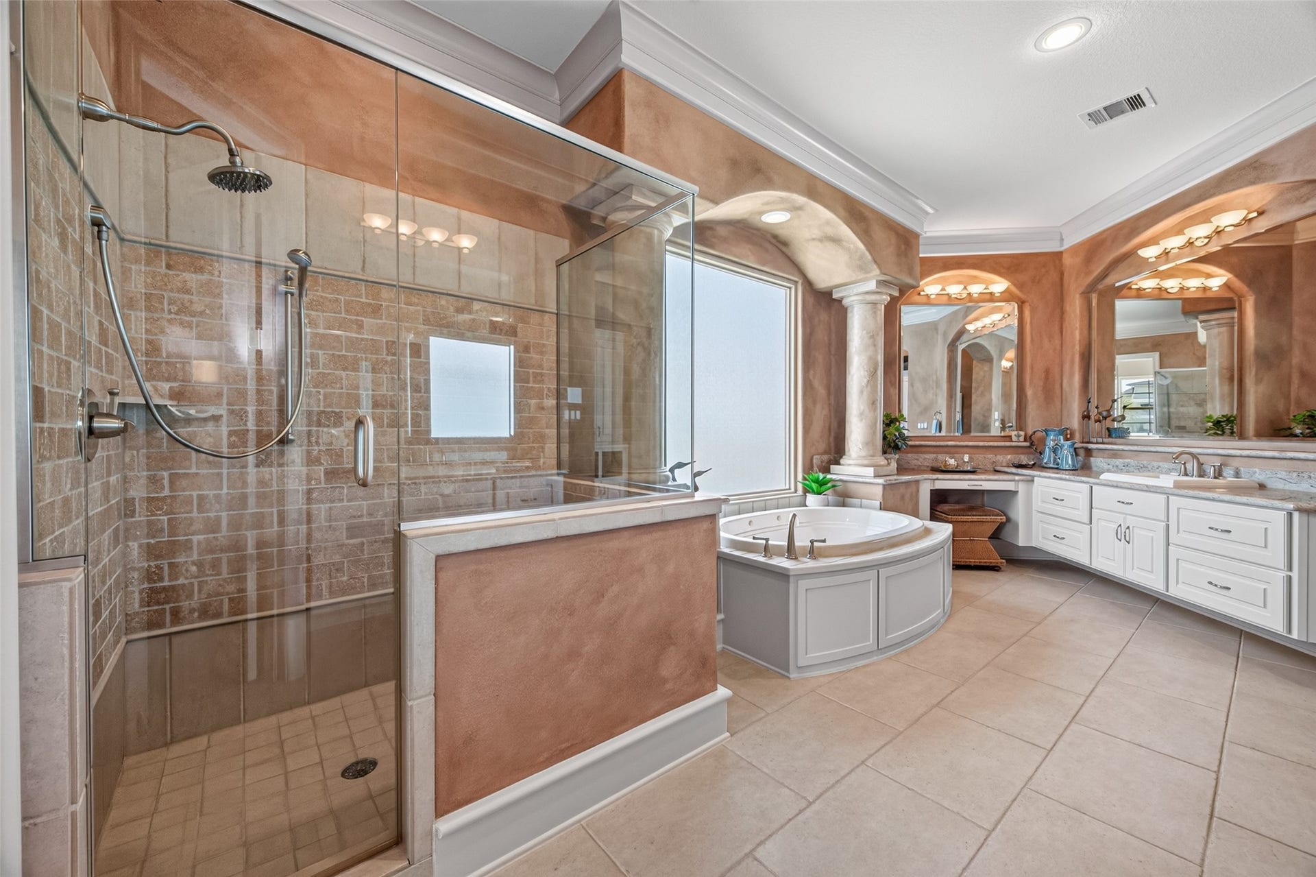 13 Sugarloaf, Hitchcock, TX 77563 Luxurious bathroom featuring a spacious glass-enclosed shower, elegant soaking tub, and dual vanities with ample counter space, all accented by warm tones and stylish finishes.