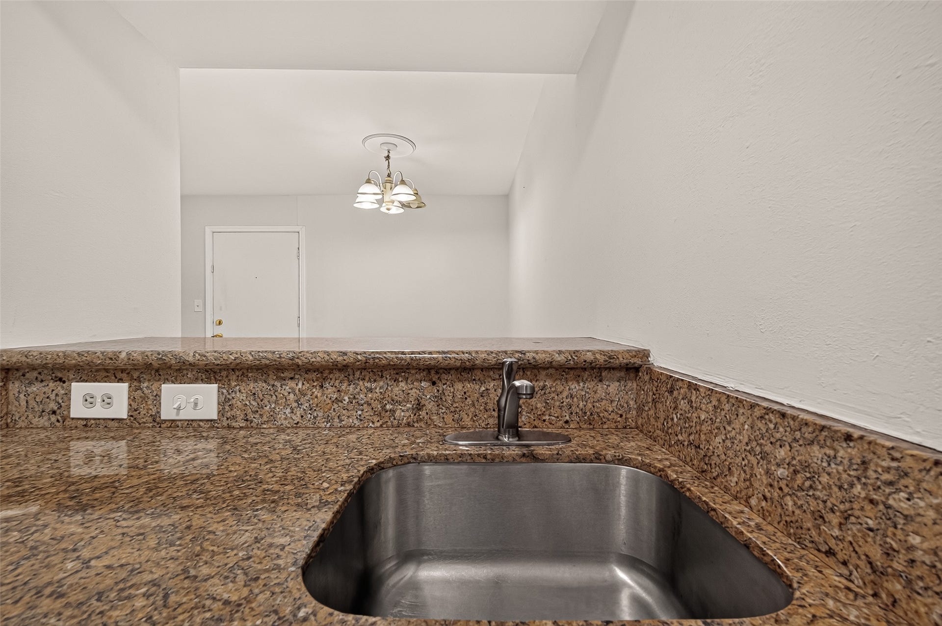 5353 Richmond Avenue, #12, Houston, TX 77056 Elegant granite countertops with a built-in stainless steel sink provide a sleek and functional kitchen space, complemented by modern lighting fixtures.