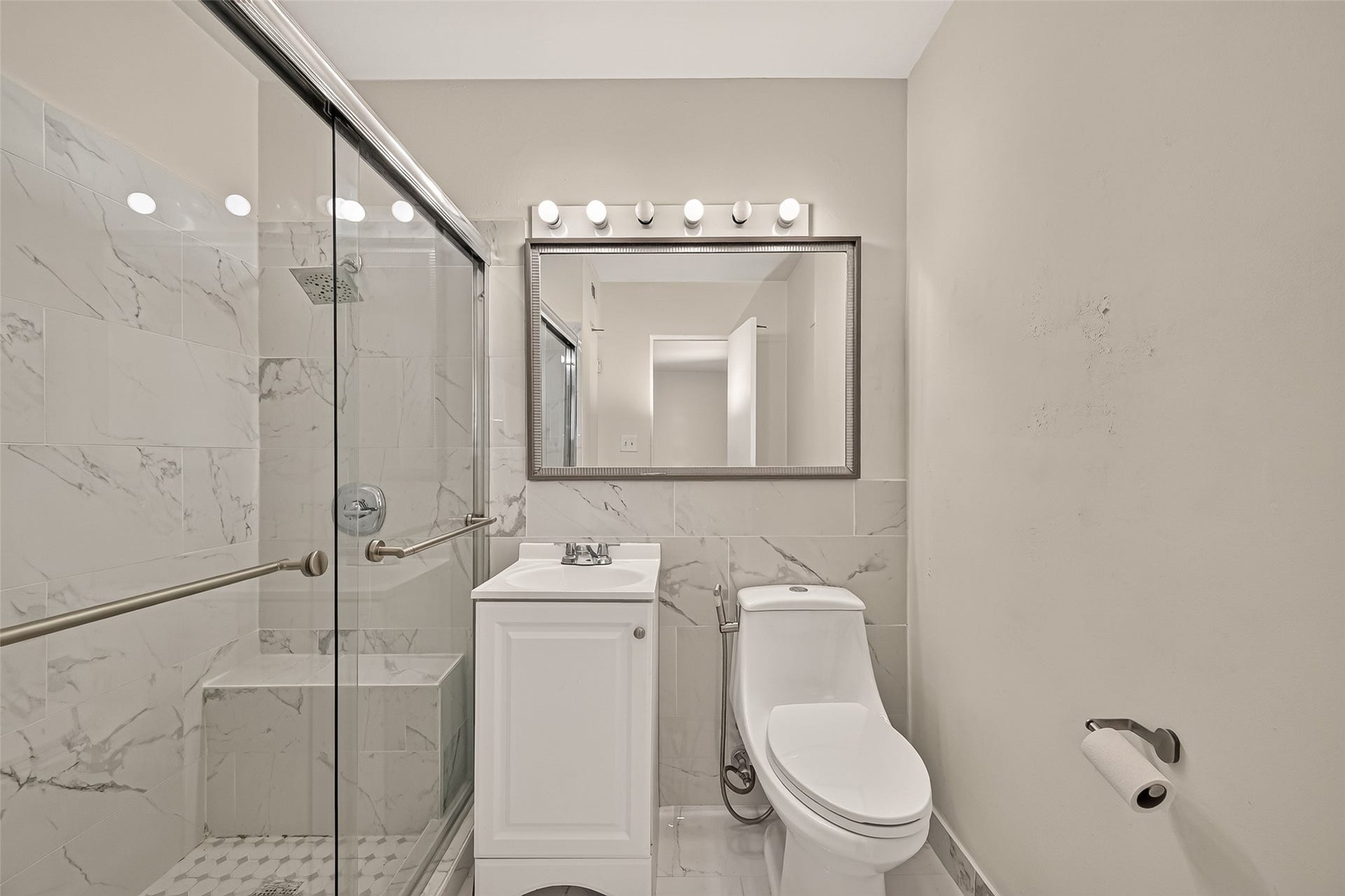 5353 Richmond Avenue, #12, Houston, TX 77056 Sleek bathroom featuring a glass-enclosed shower with elegant marble tiles, a modern vanity, and ample lighting for a bright and inviting space.