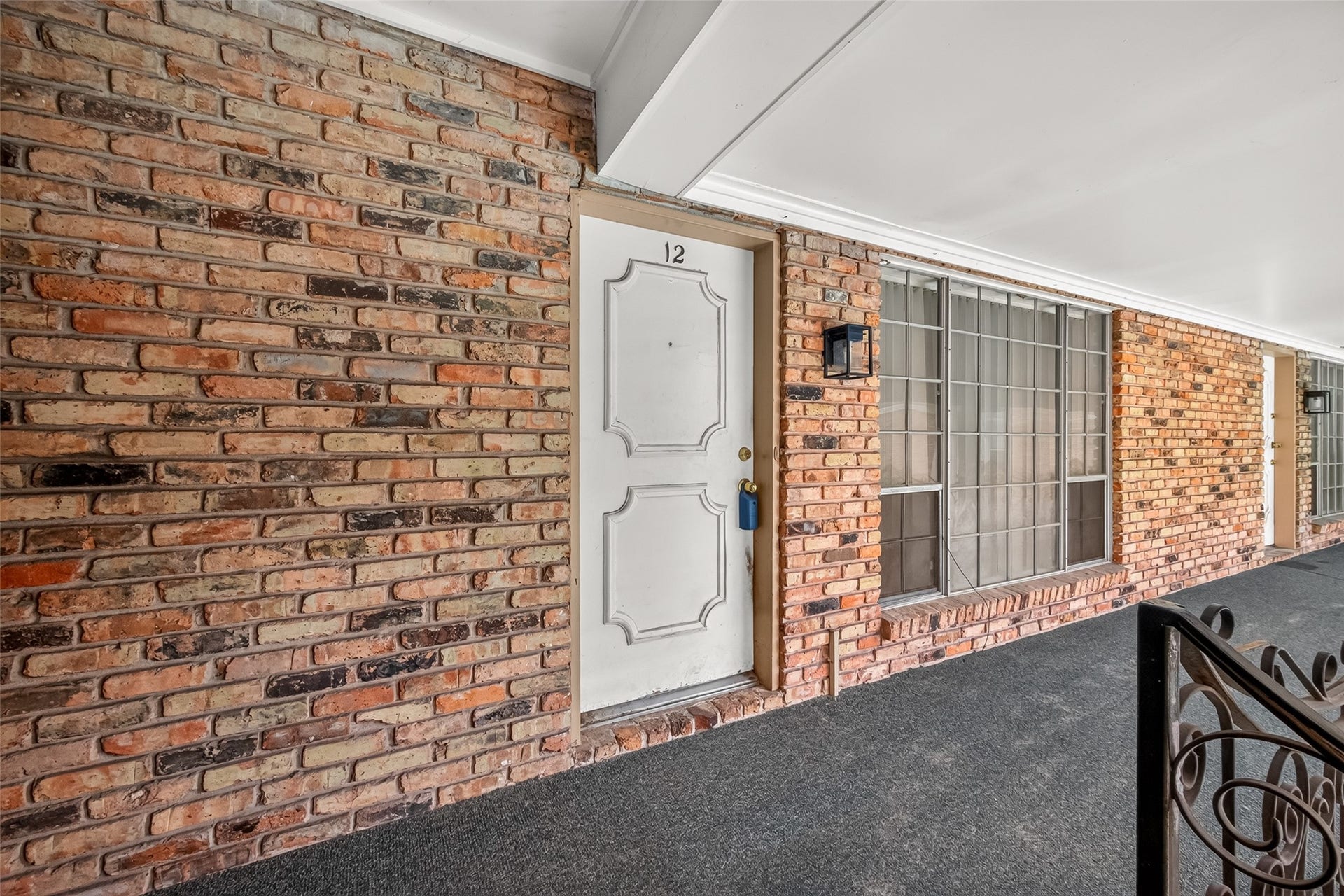 5353 Richmond Avenue, #12, Houston, TX 77056 Charming brick exterior with a classic white door and large windows, offering a welcoming entrance.