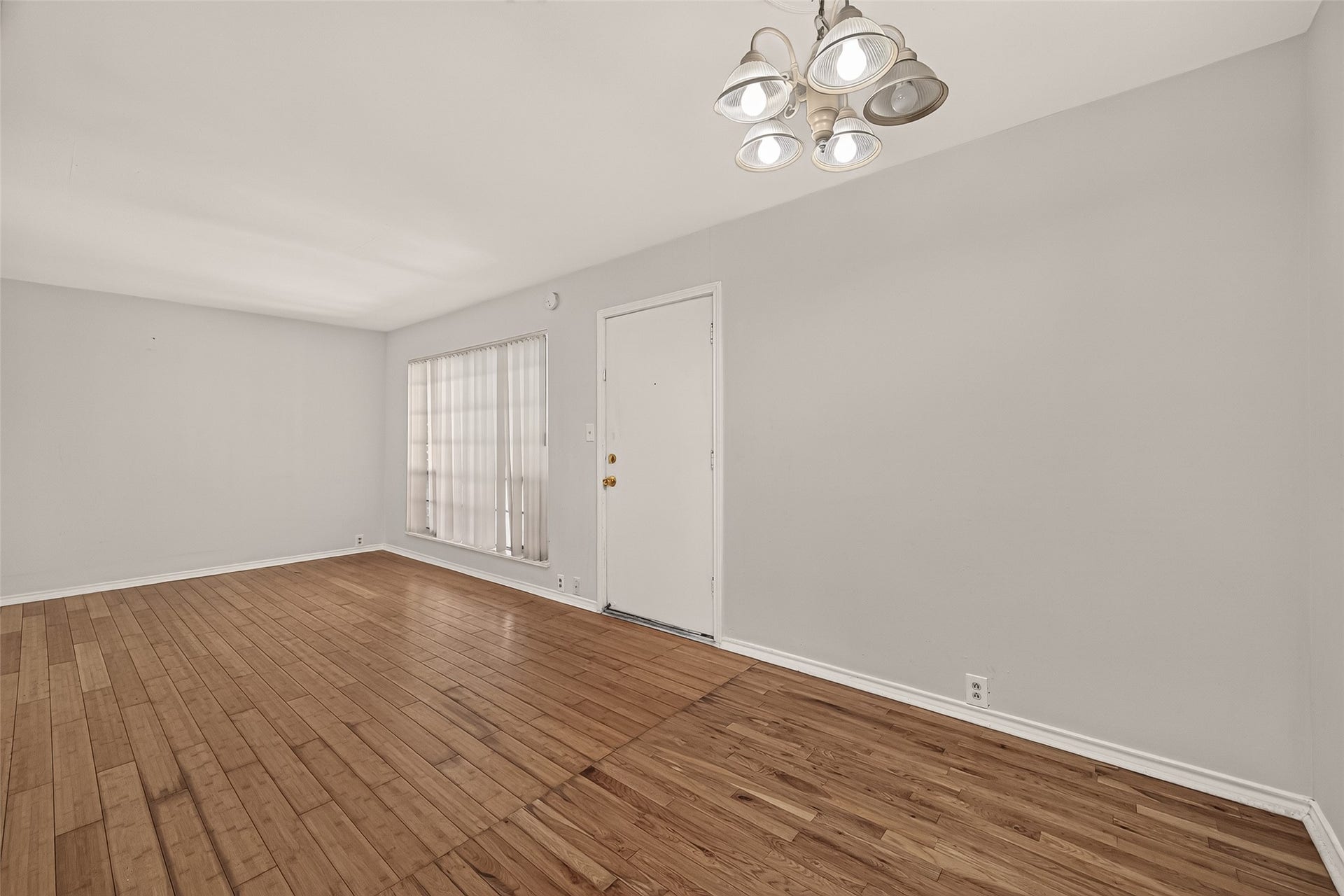 5353 Richmond Avenue, #12, Houston, TX 77056 Bright and spacious room featuring elegant hardwood floors, neutral walls, and a stylish light fixture, creating a welcoming atmosphere.