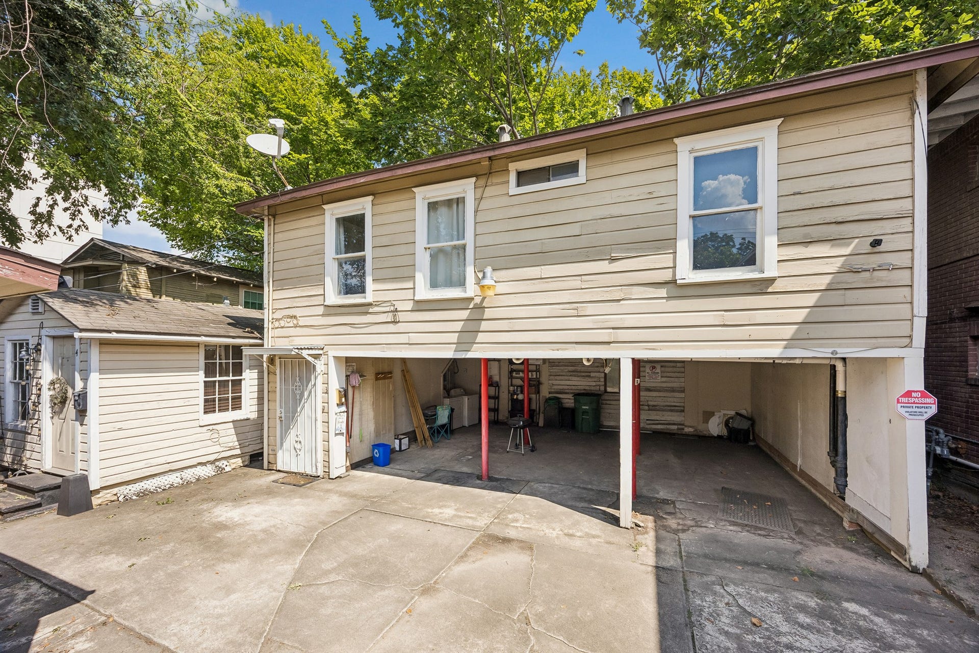 A view of the private bungalow on the left and the garage apartment above the covered parking. A shared washer/dryer are located in the parking area.