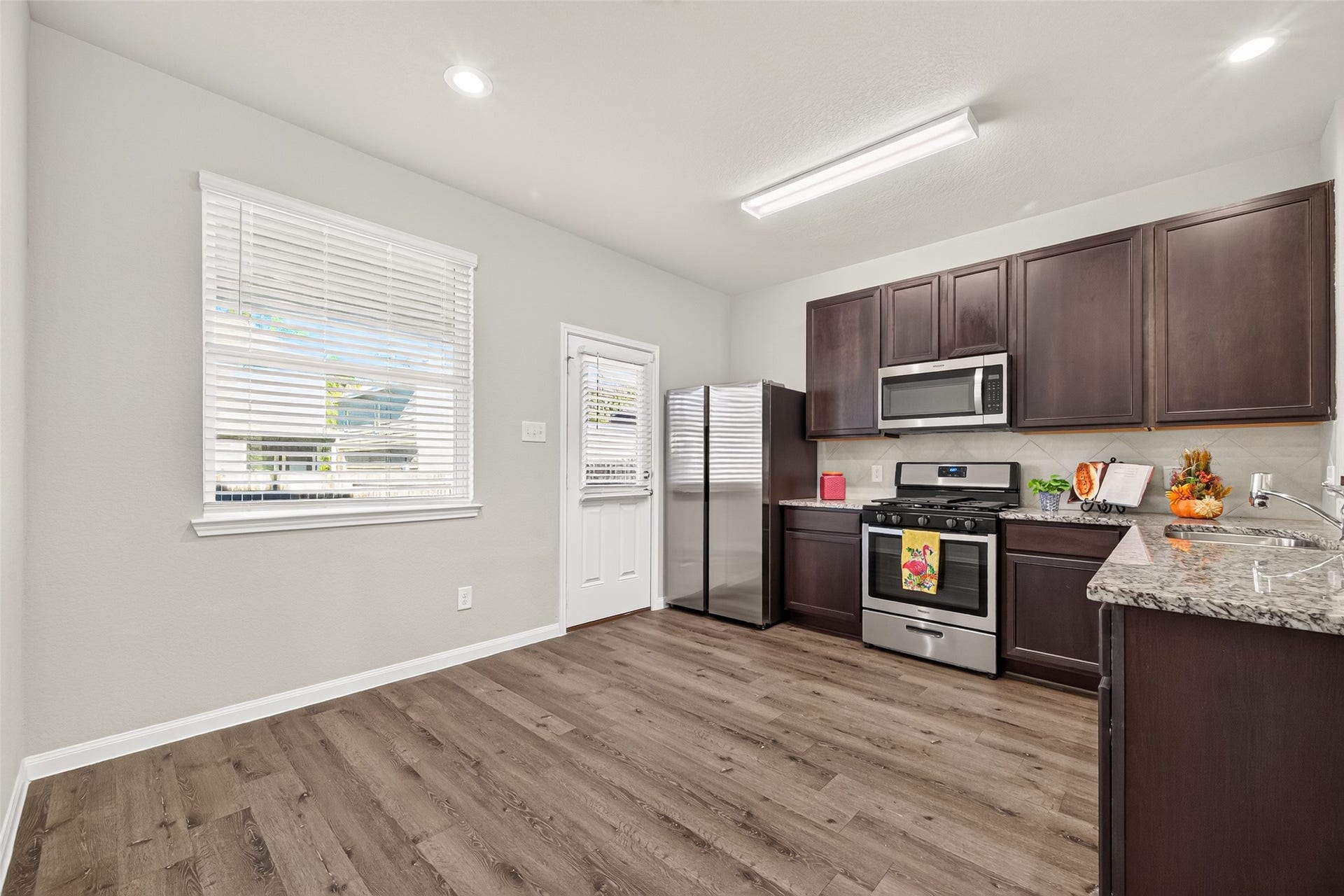 13405 Cannon Creek Court, Willis, TX 77378 Modern kitchen with sleek stainless steel appliances, dark wood cabinetry, and elegant granite countertops, offering ample space and natural light.