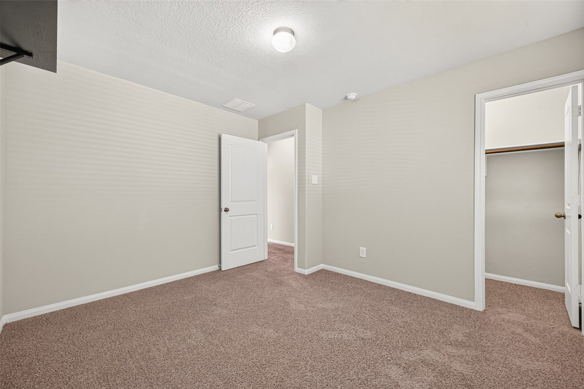 13405 Cannon Creek Court, Willis, TX 77378 Bedroom 3 view 2 with soft carpeting, neutral walls, and a convenient walk-in closet, creating a welcoming and functional space.