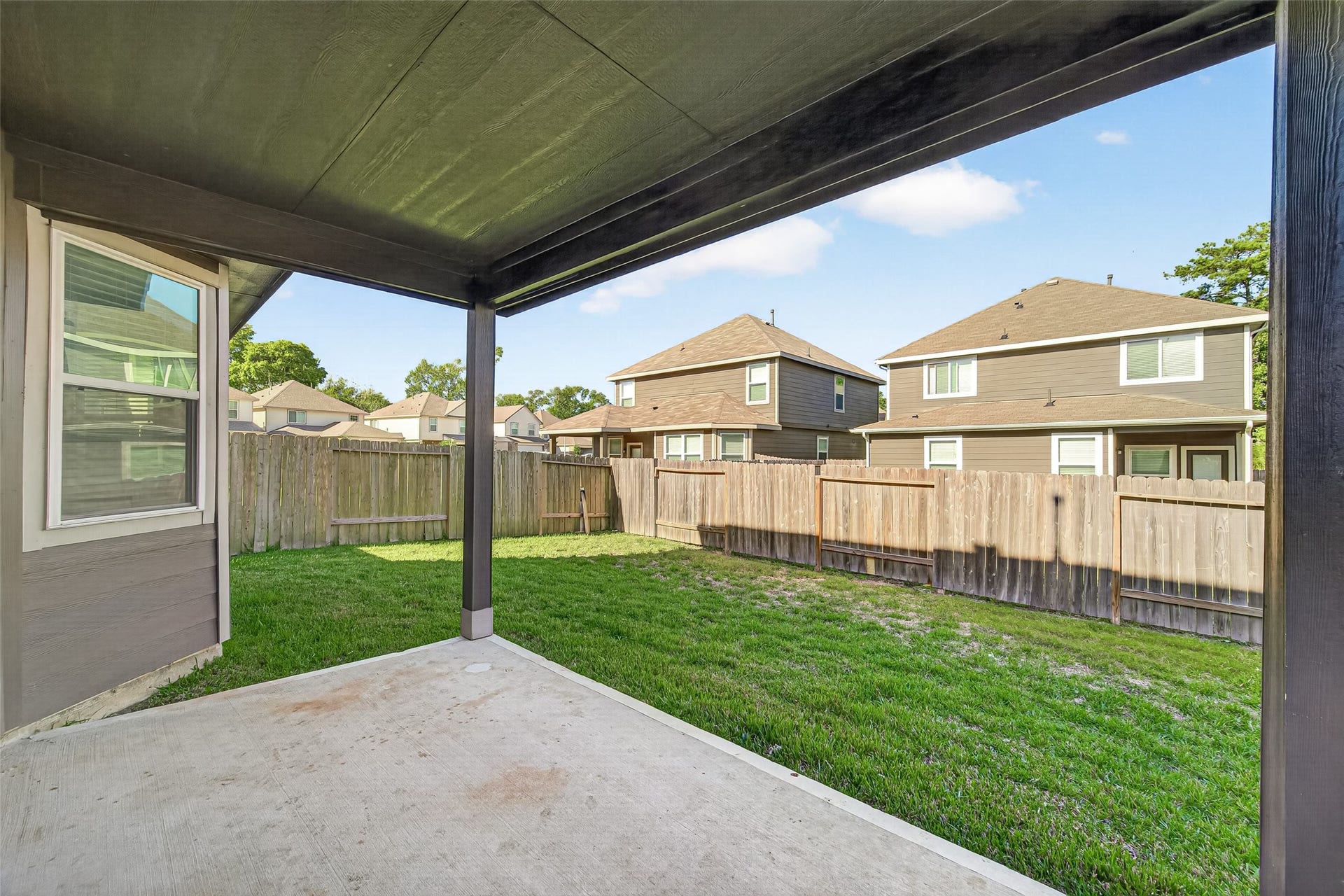 13405 Cannon Creek Court, Willis, TX 77378 Nice size backyard with a covered patio, perfect for outdoor relaxation and entertaining, surrounded by a wooden privacy fence.