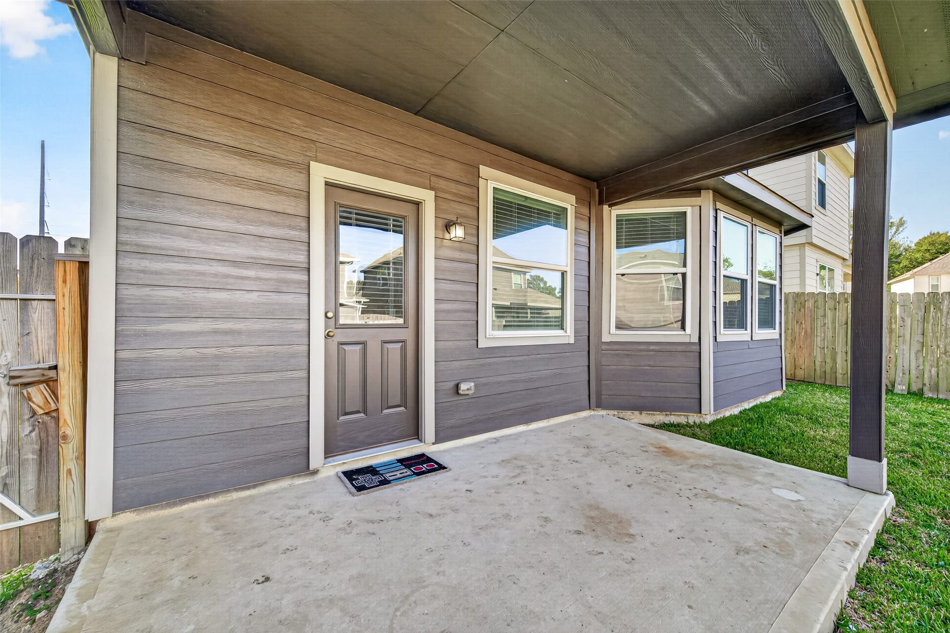 13405 Cannon Creek Court, Willis, TX 77378 Charming covered patio area with concrete flooring, perfect for outdoor relaxation and entertainment, surrounded by a privacy fence for added seclusion.