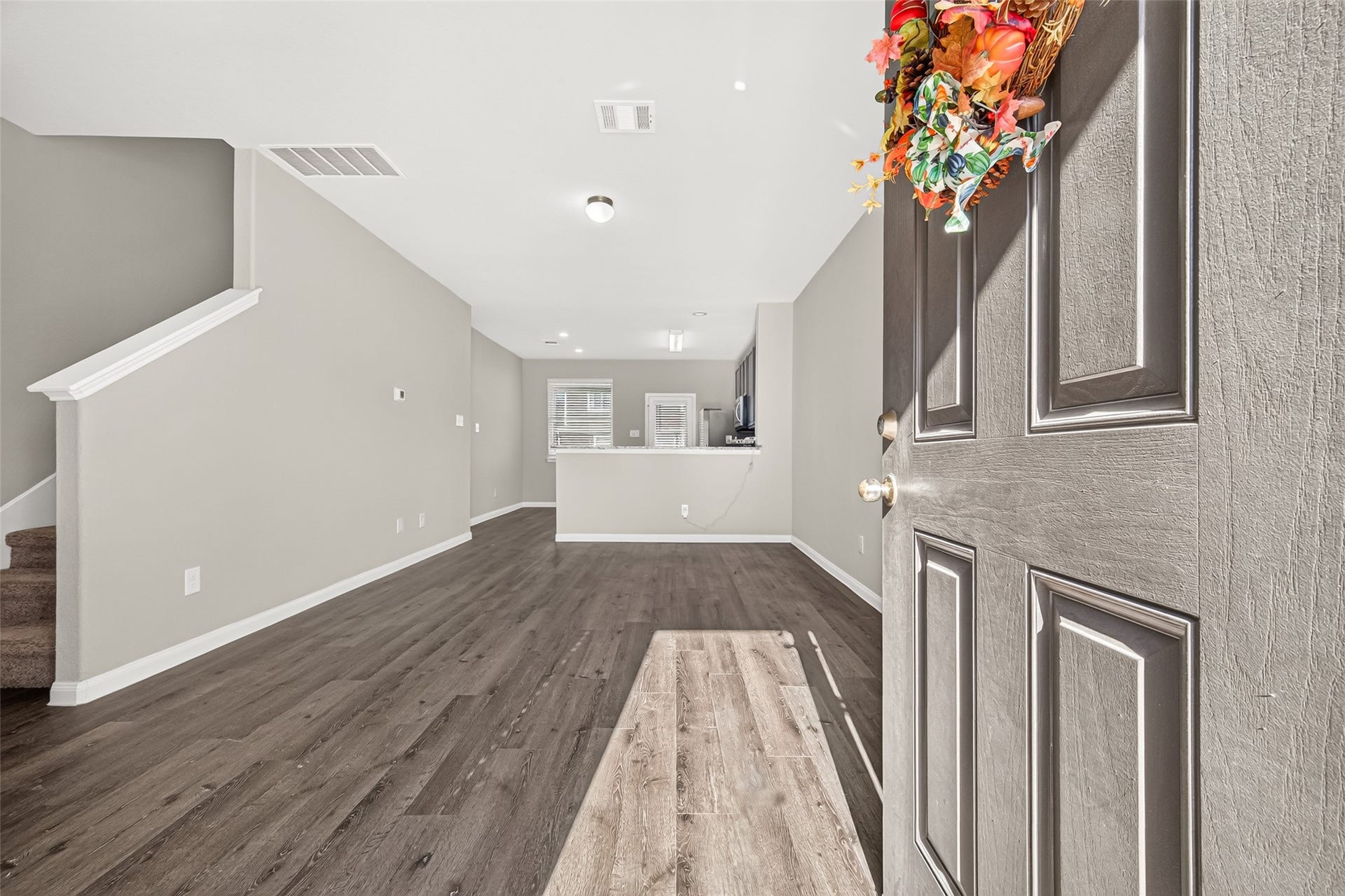 13405 Cannon Creek Court, Willis, TX 77378 Step into this inviting open-concept living space featuring elegant luxury vinyl plank floors, neutral tones, and a cozy atmosphere perfect for relaxation and entertaining.