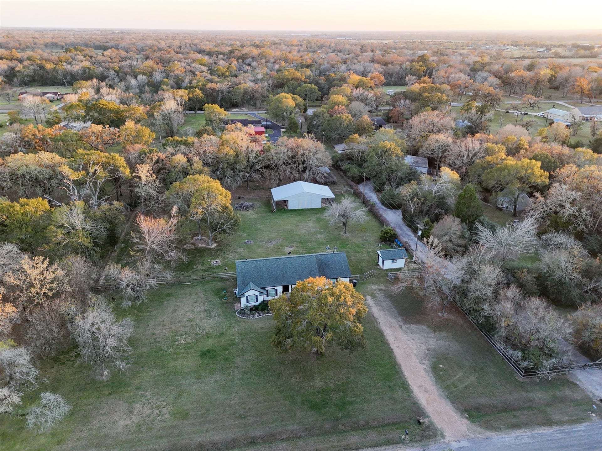 Aerial view highlighting the homes setting among mature trees with wide open space and privacy.