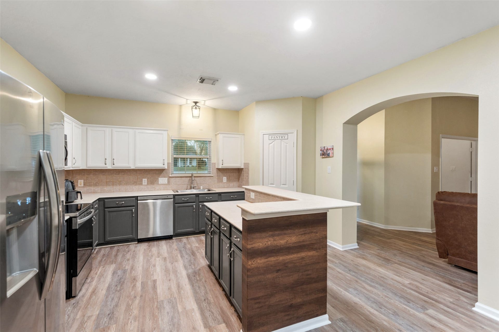 Open-concept kitchen with breakfast bar seating, pantry storage, and seamless flow to living areas.