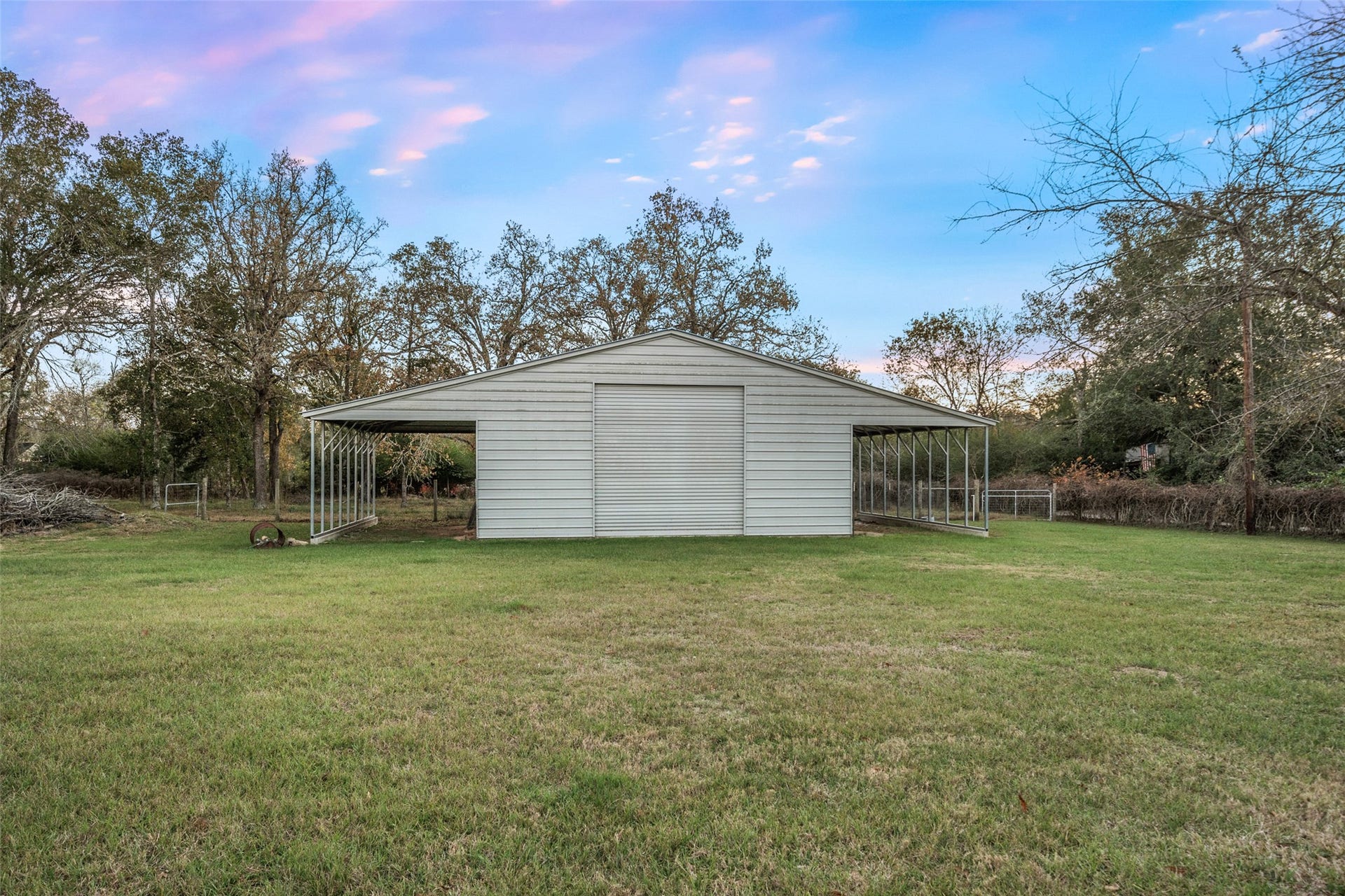 Detached barn with roll-up door and open bays, suitable for equipment storage, workshop use, or hobby space.