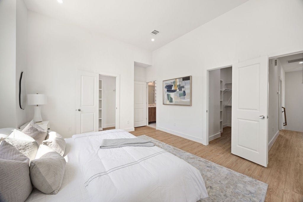 Spacious primary suite featuring a luxurious en suite bath and dual walk in closets.