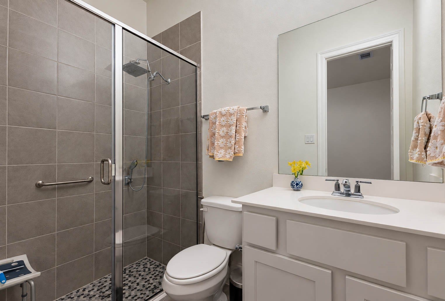 4839 Summer Place Court, Fulshear, TX 77441 Modern bathroom featuring a spacious glass-enclosed shower with sleek gray tiles, a white vanity with ample storage, and a large mirror, creating a bright and inviting space.
