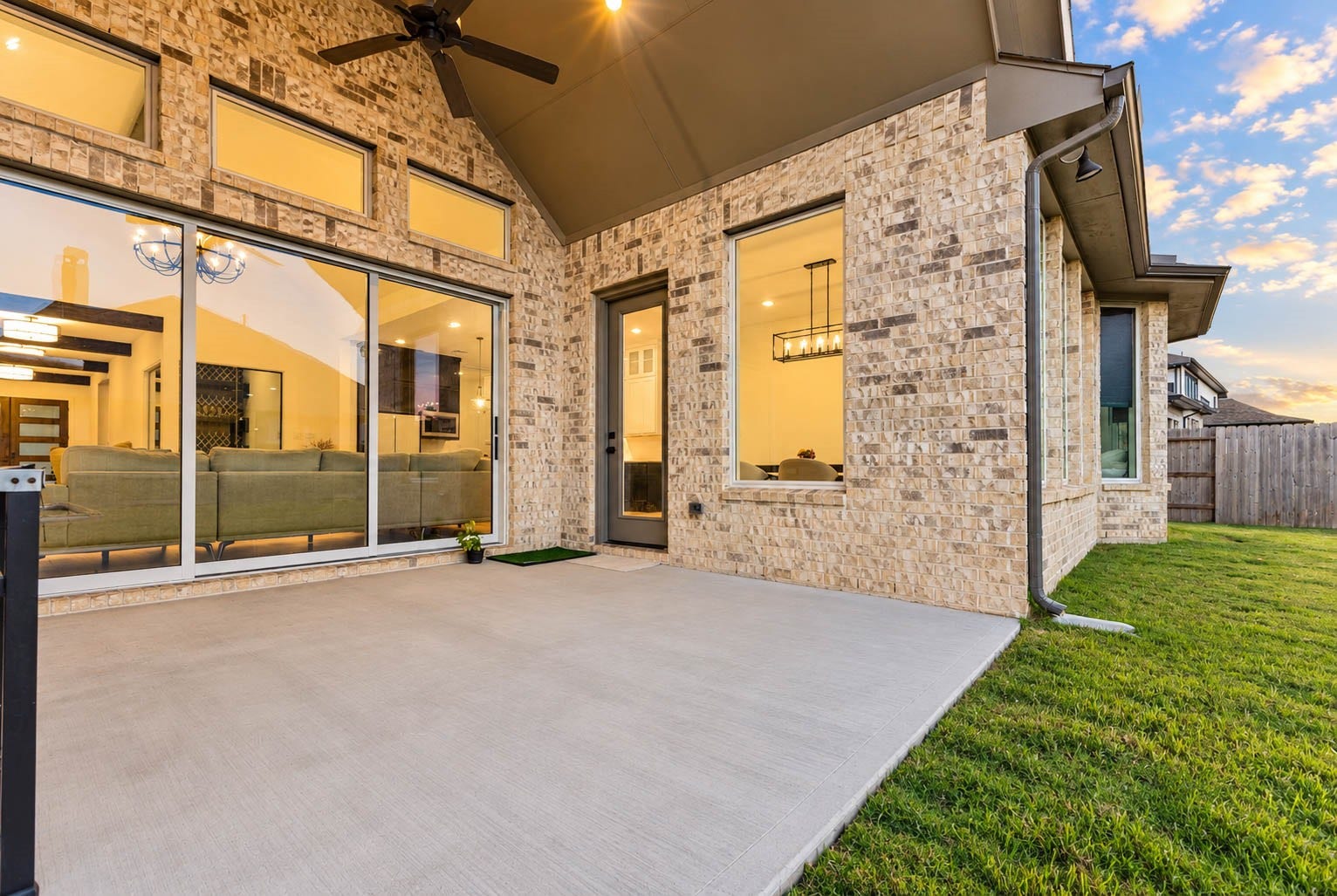 4839 Summer Place Court, Fulshear, TX 77441 Elegant outdoor patio with a stylish brick facade and large sliding glass doors, seamlessly connecting indoor and outdoor living spaces.