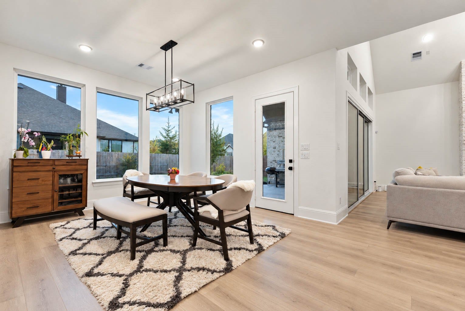 4839 Summer Place Court, Fulshear, TX 77441 Bright and inviting dining area featuring large windows, a modern chandelier, and seamless flow into the living space, perfect for entertaining.